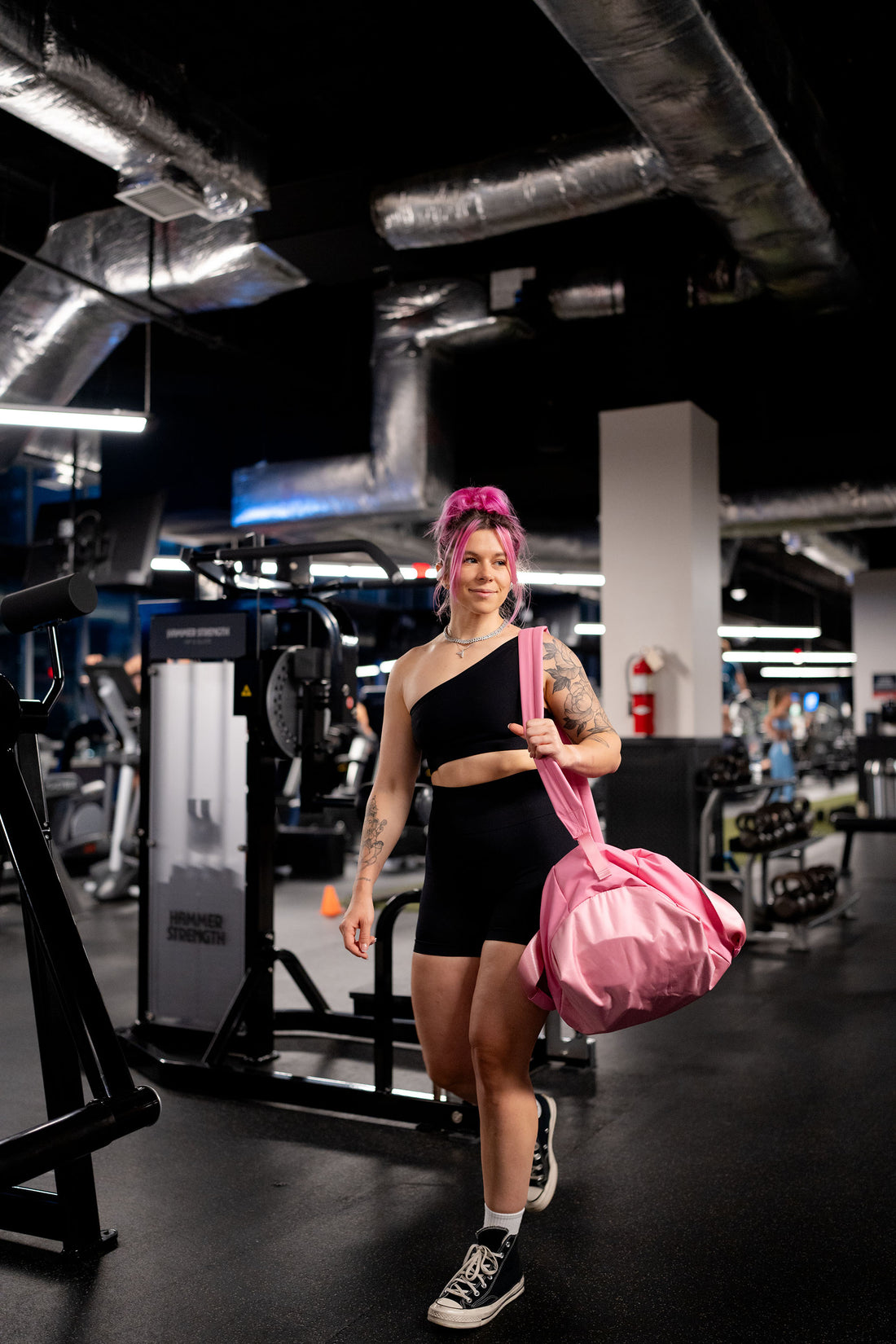 woman walking around with pink gym bag uppper