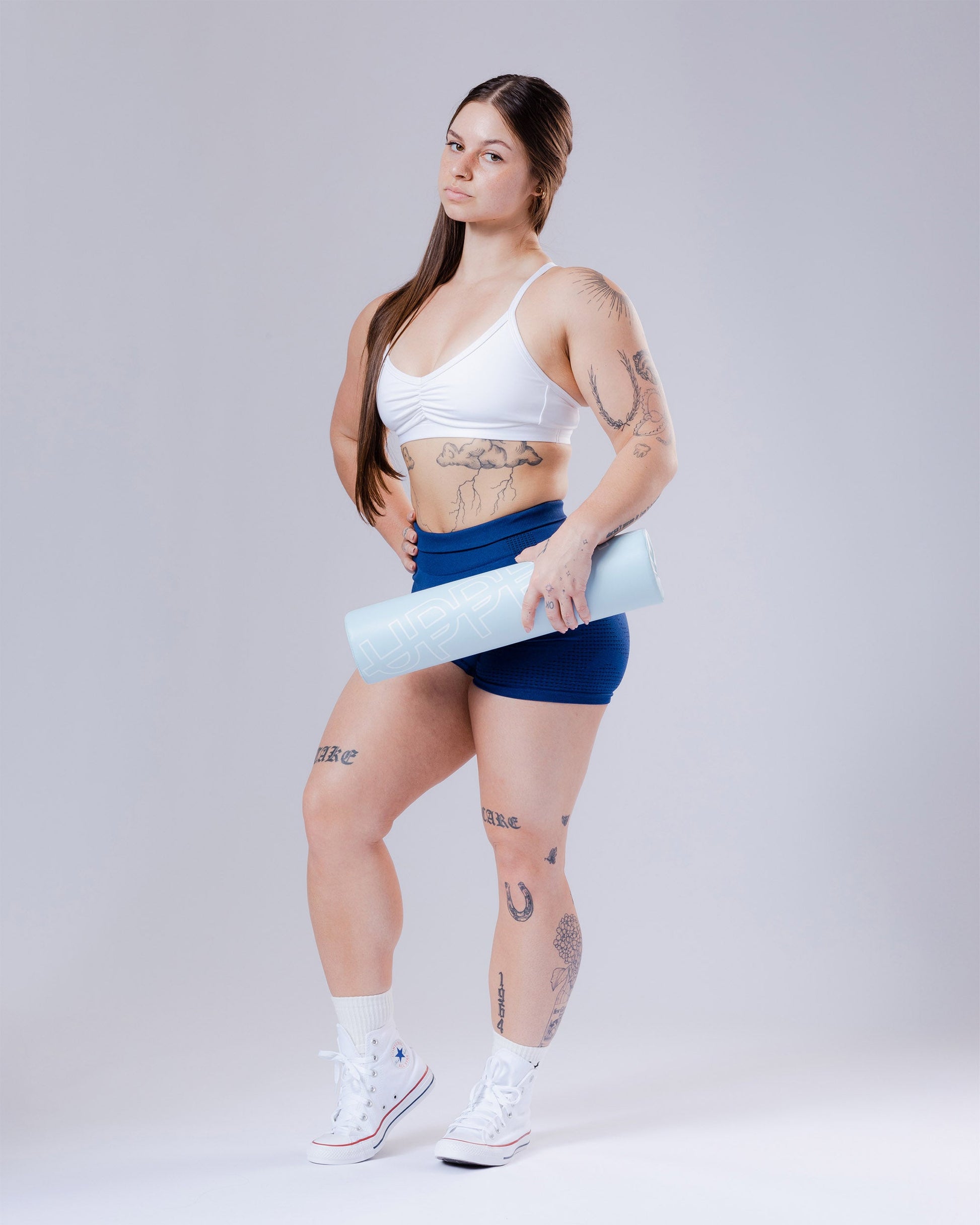 model posing with baby blue uppper barbell studio shot on grey background