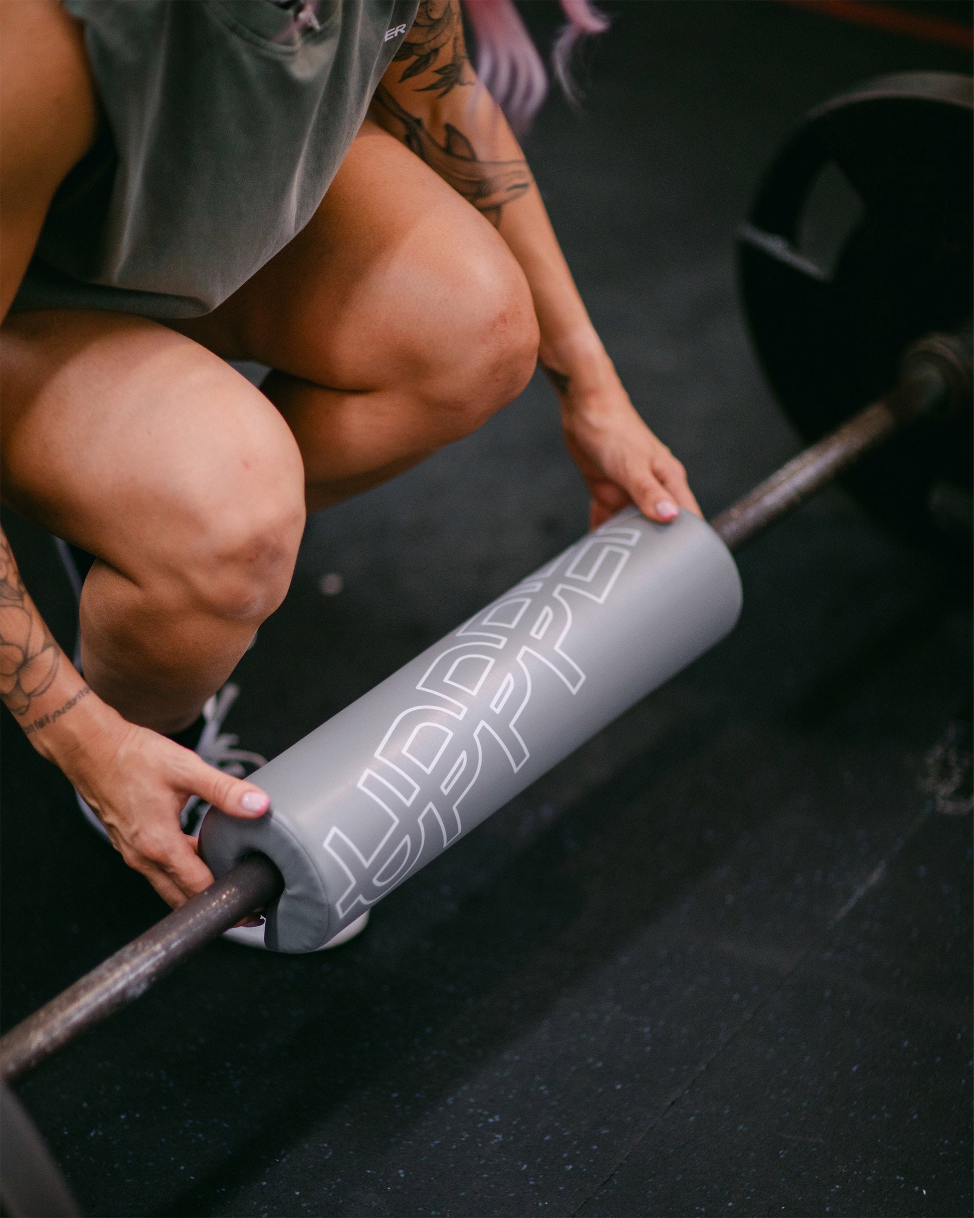 grey uppper barbell pad shown wrapped around a barbell