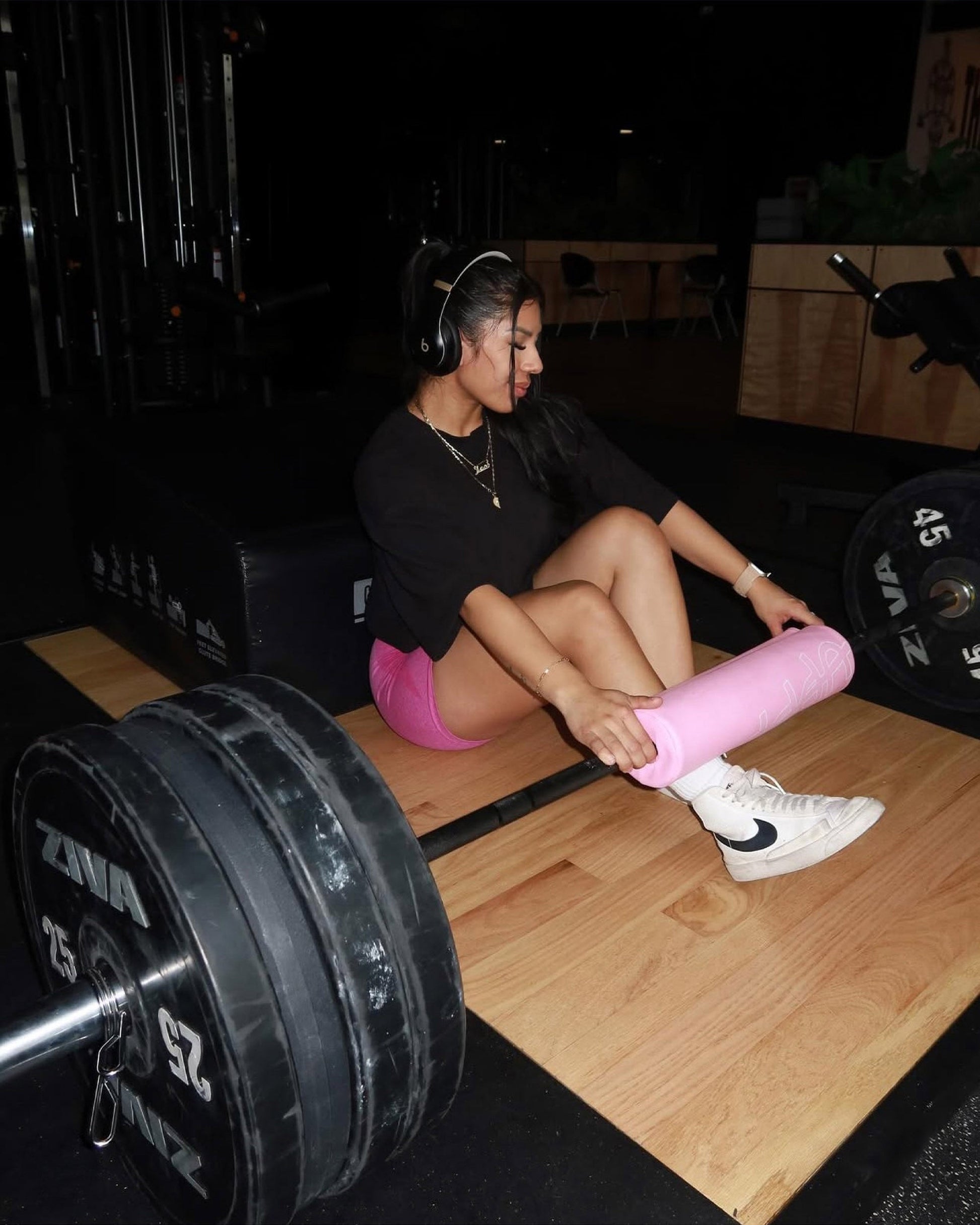 athlete holding pink uppper barbell pad set on bar during exercise