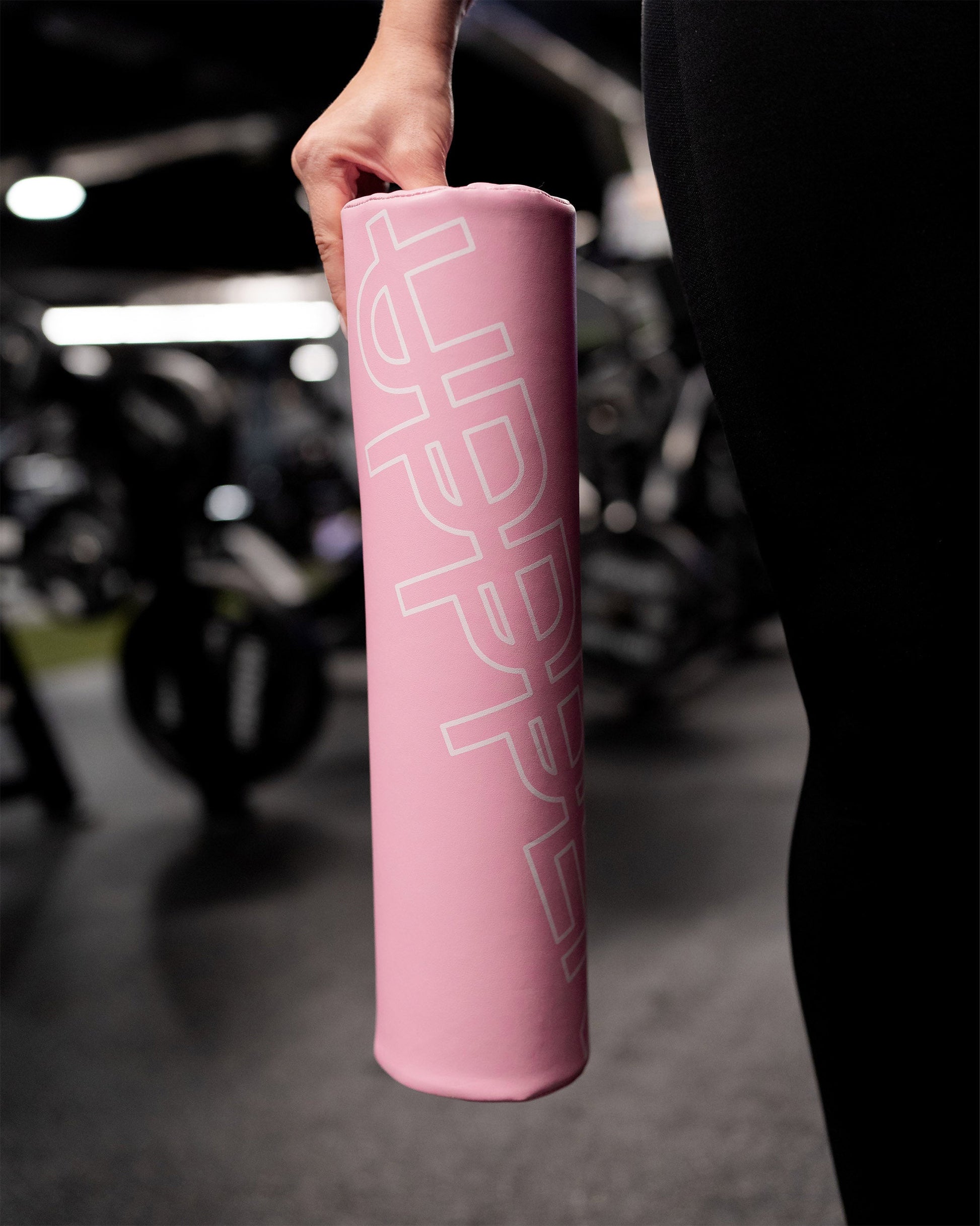 hand holding pink uppper barbell pad in gym