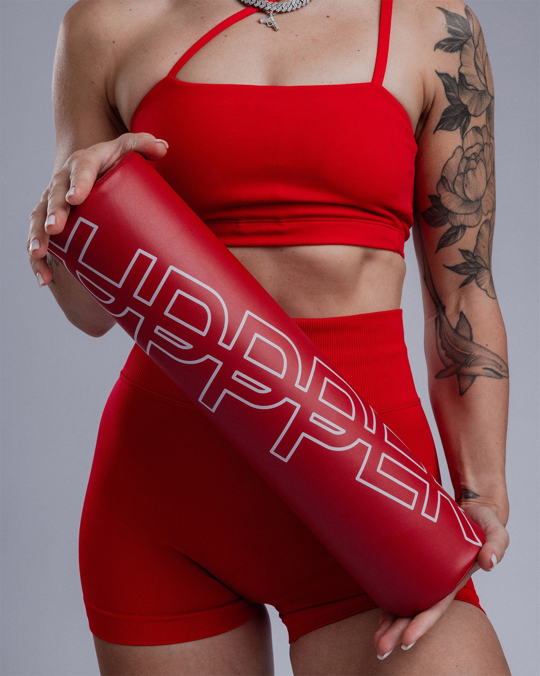 athlete holding red uppper barbell pad showing logo