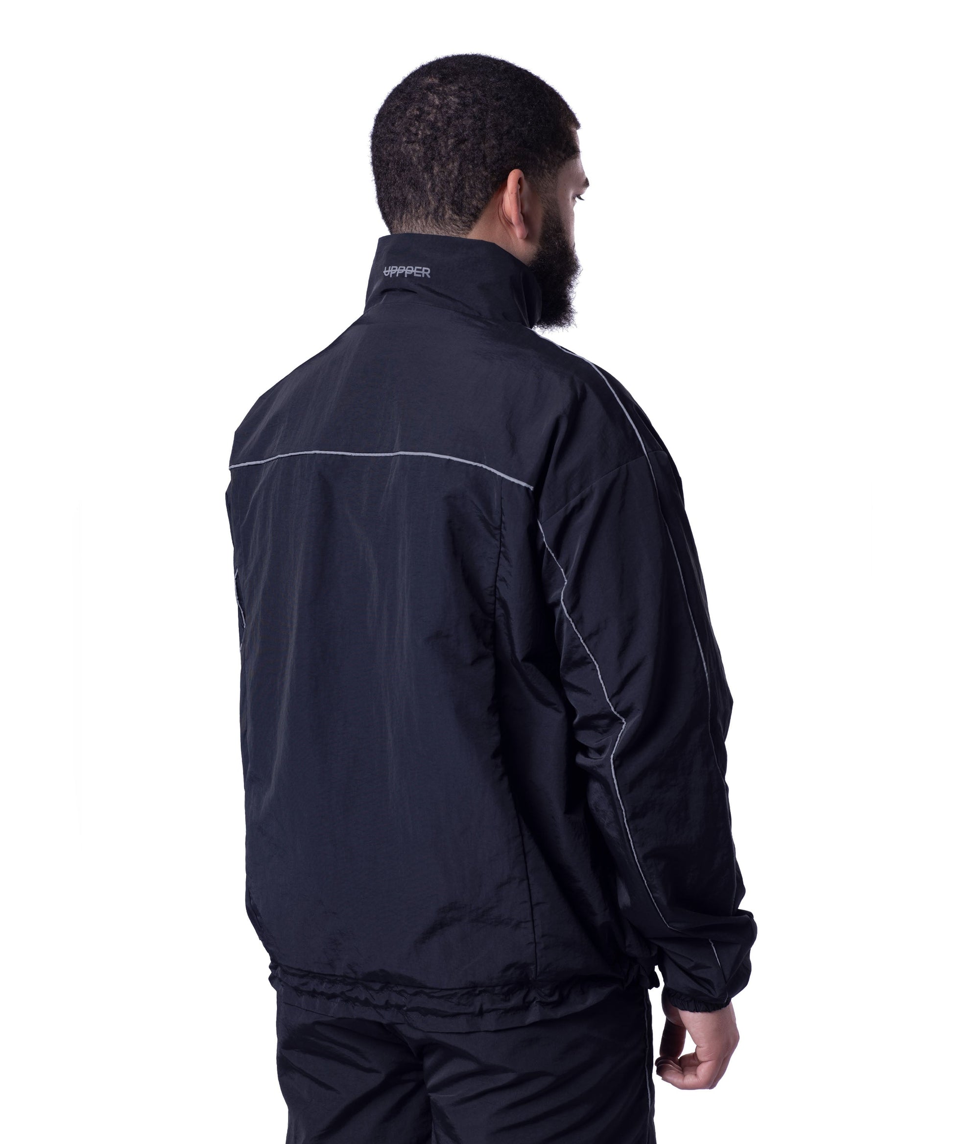 back of black uppper track jacket showing reflective lines on white background