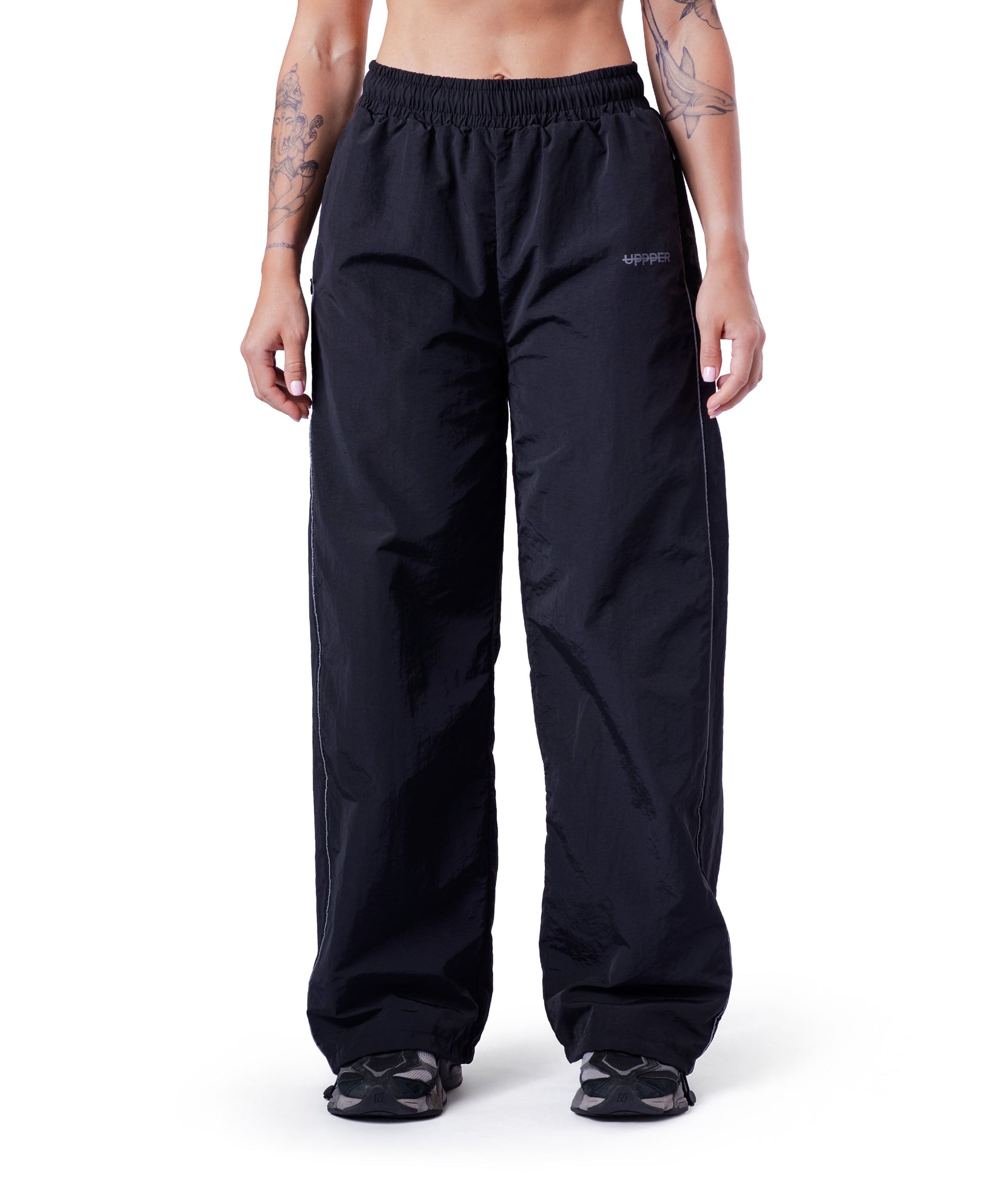 front of black uppper track pants with reflective stripe detail on white background