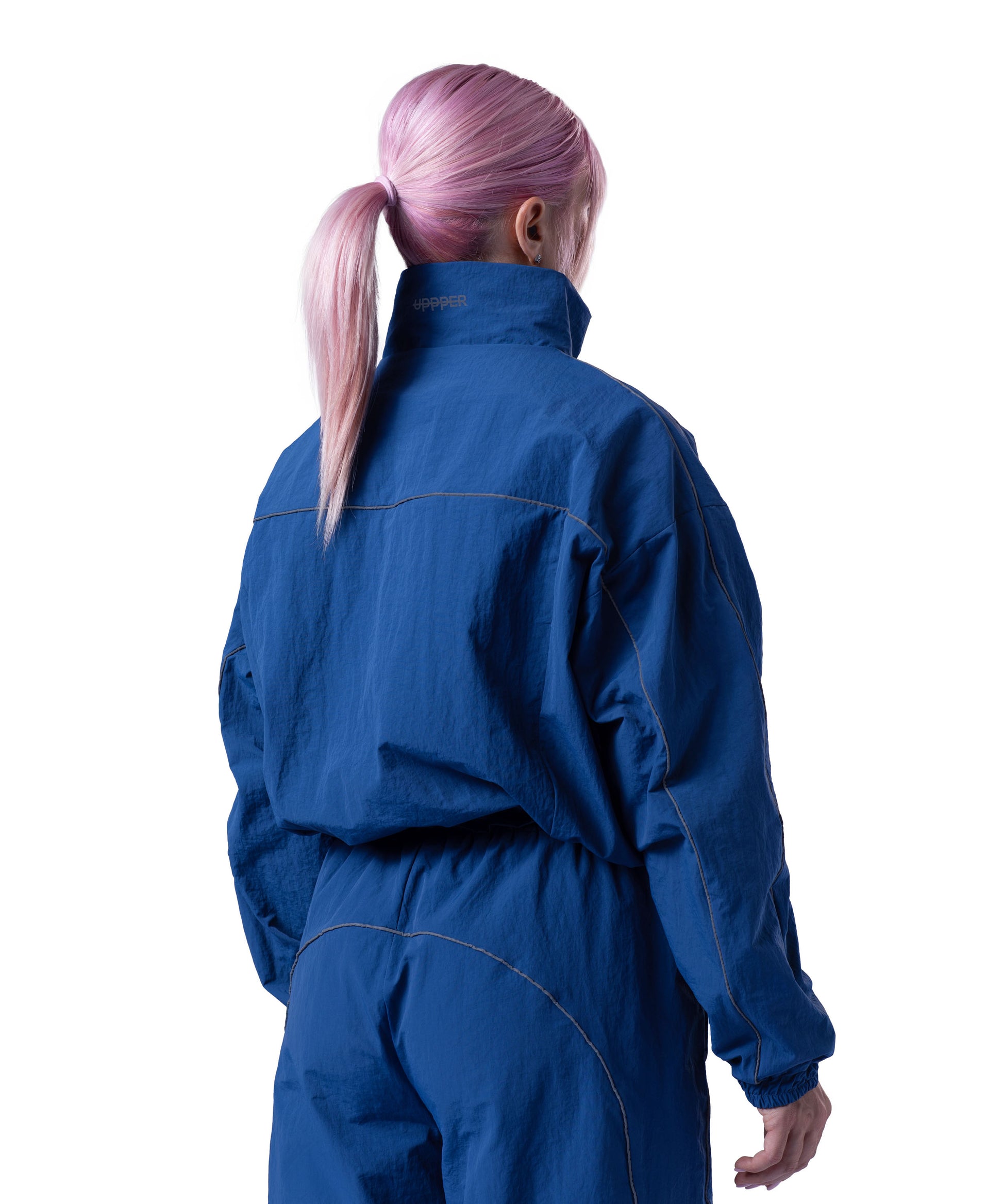 back of blue uppper track jacket showing reflective lines on white background