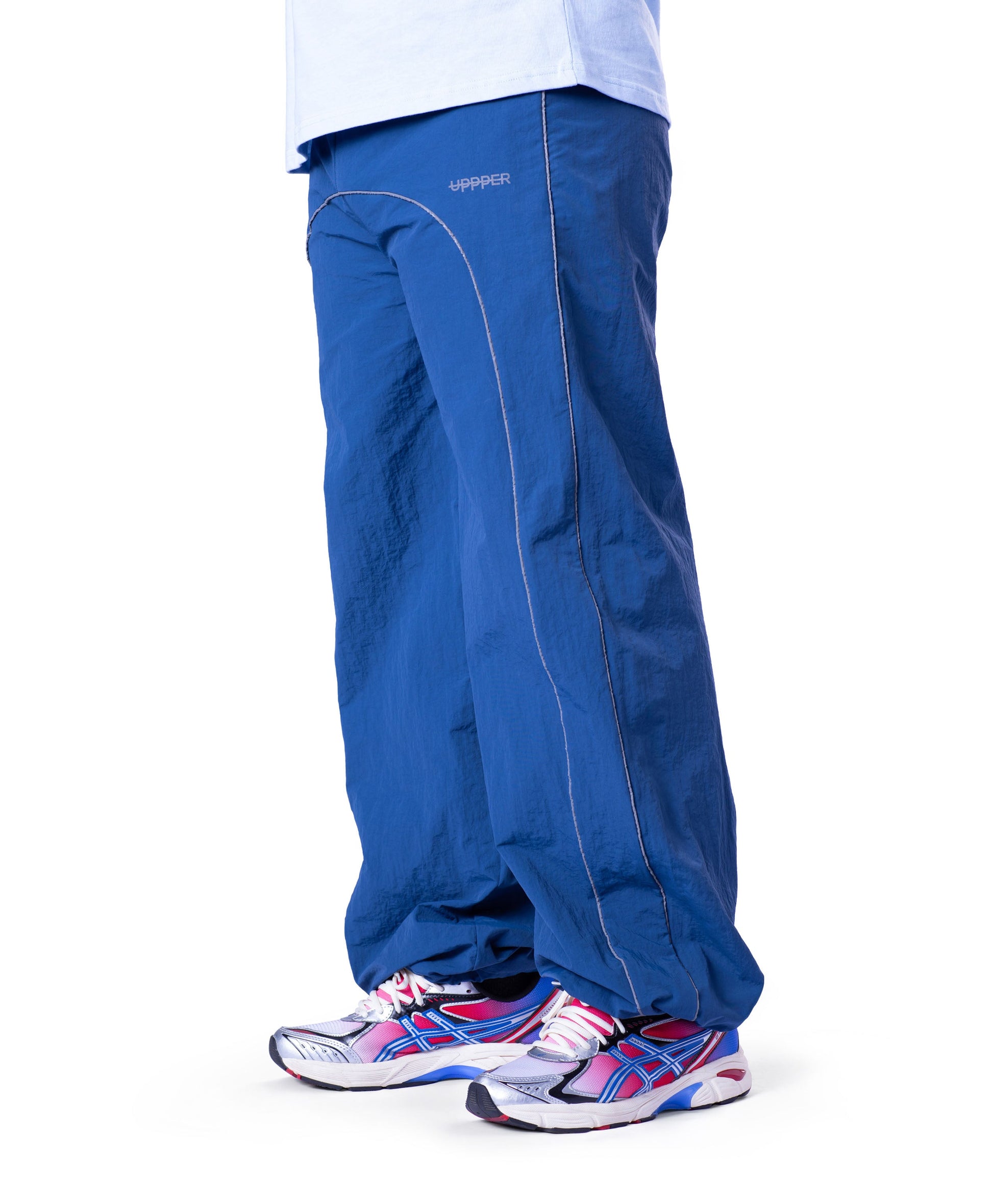 front of blue uppper track pants with reflective stripe detail on white background