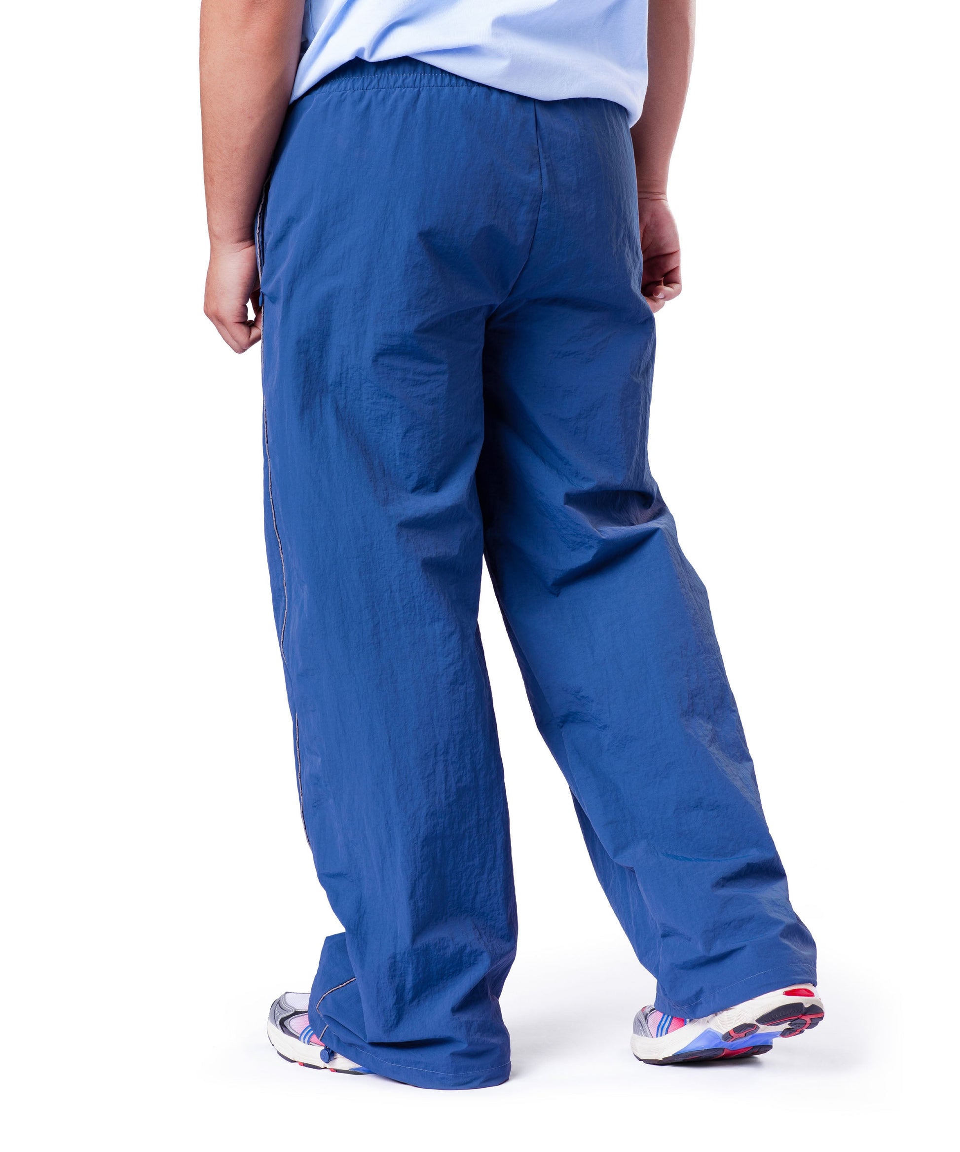 back of blue uppper track pants showing reflective lines on white background