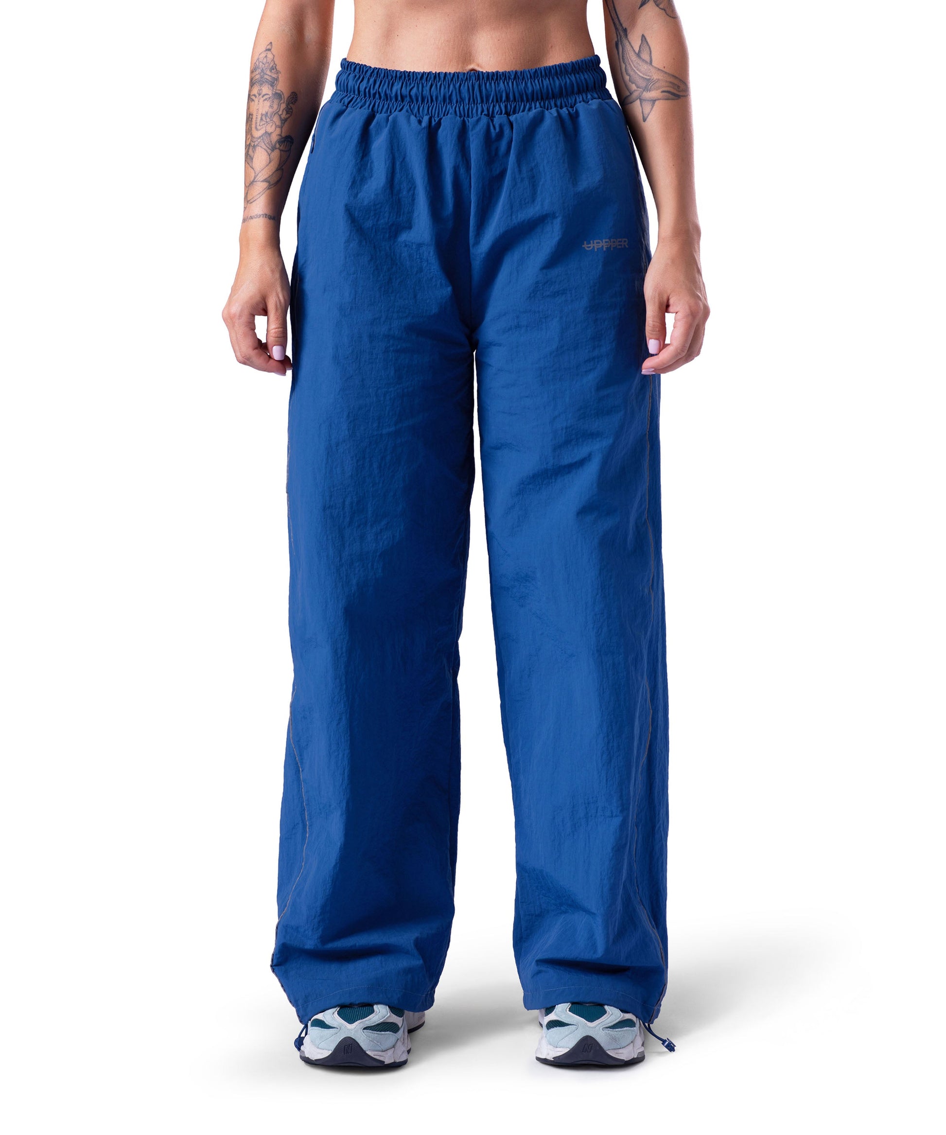 front of blue uppper track pants with reflective stripe detail on white background