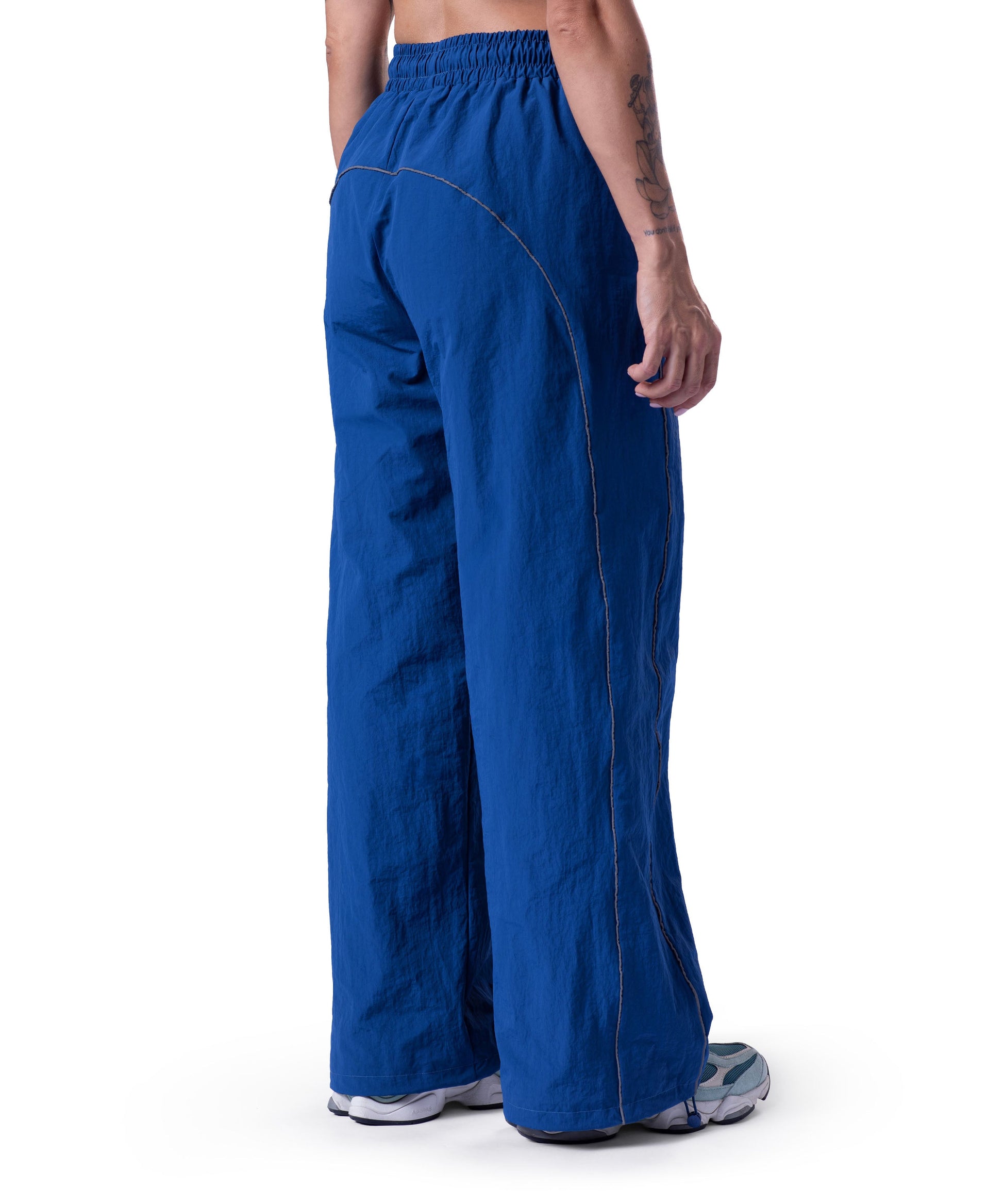 back of blue uppper track pants showing reflective lines on white background