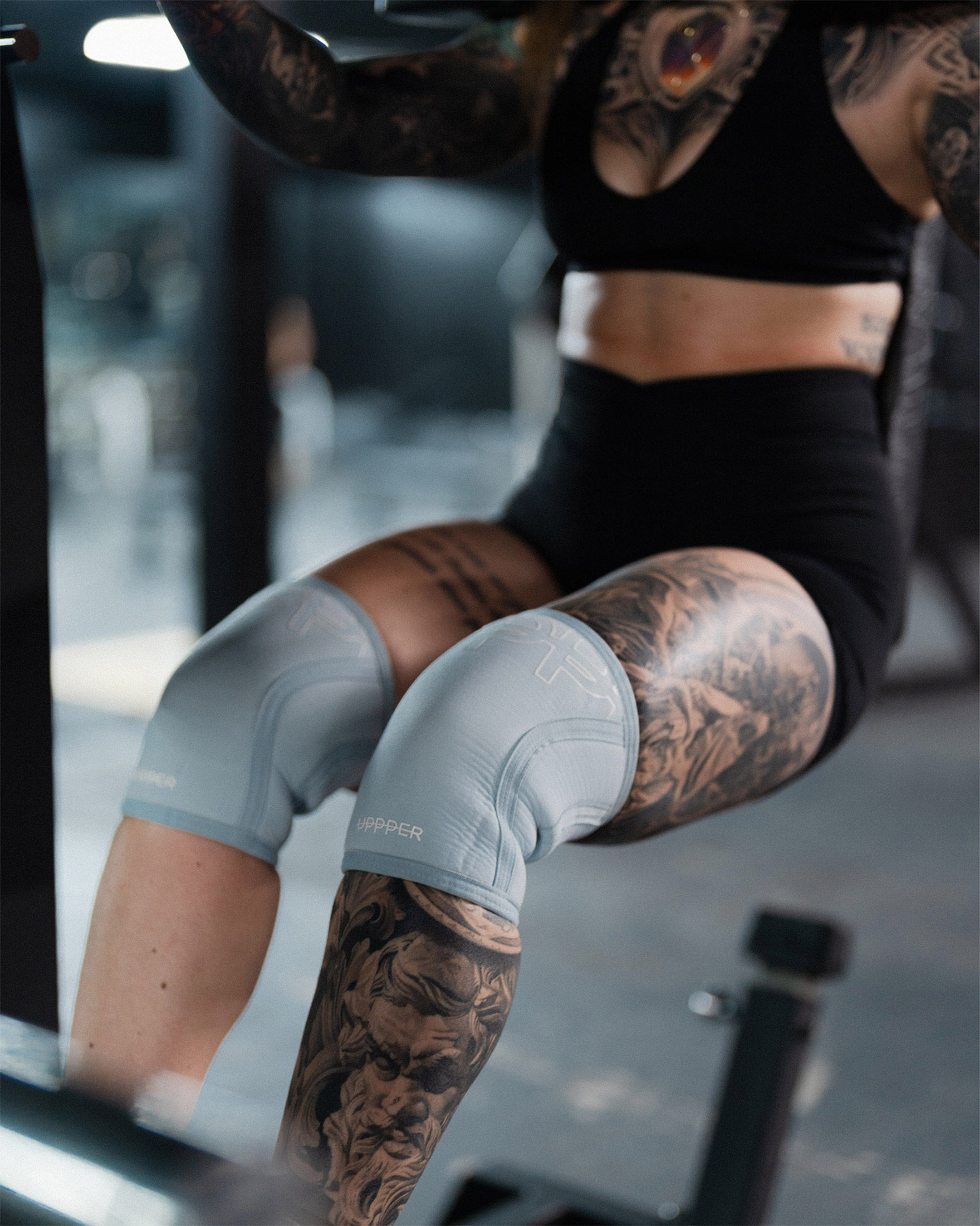 close-up of baby blue uppper knee sleeve showing embossed logo and neoprene material