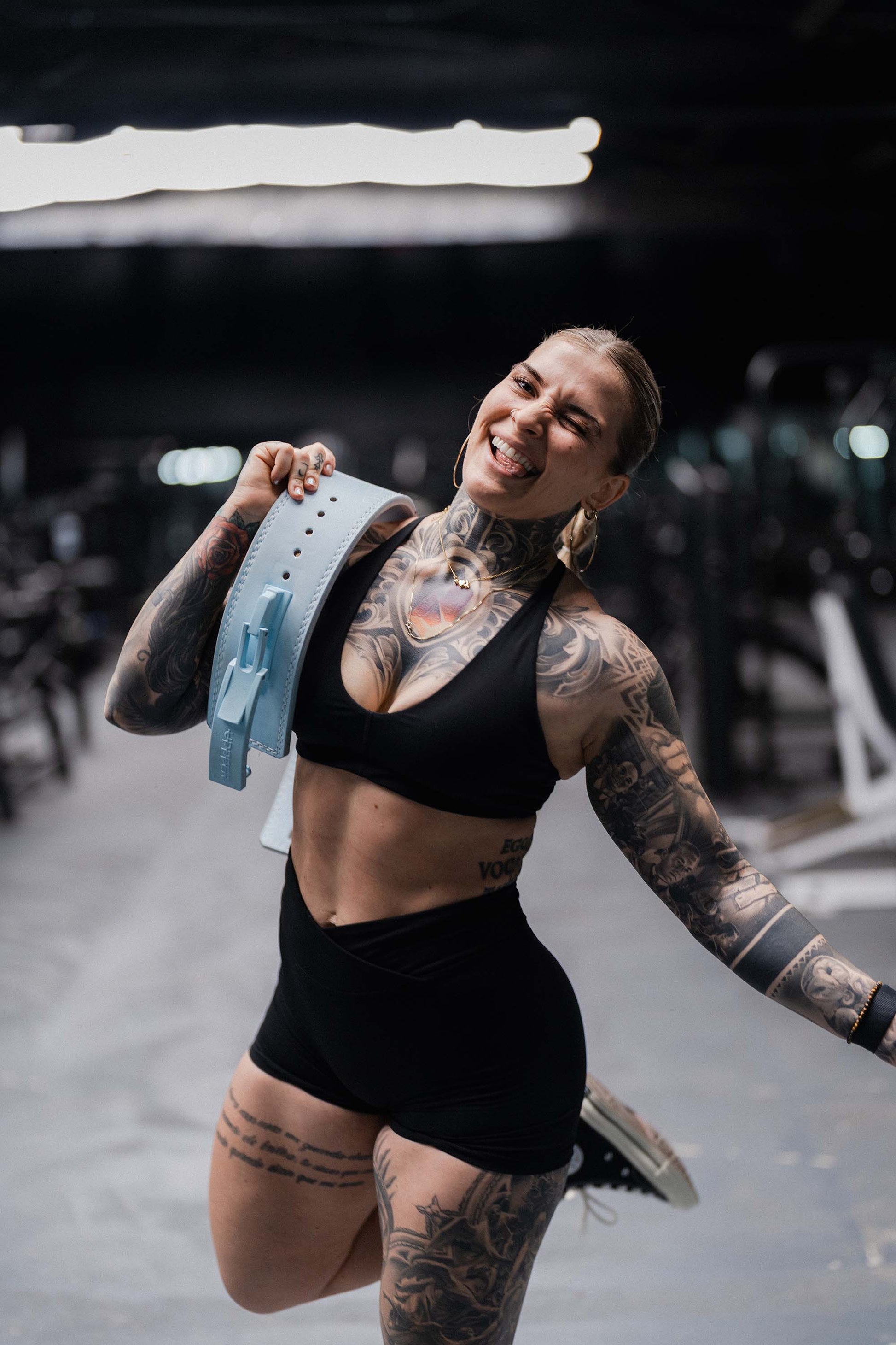athlete holding baby blue uppper lever belt in the gym
