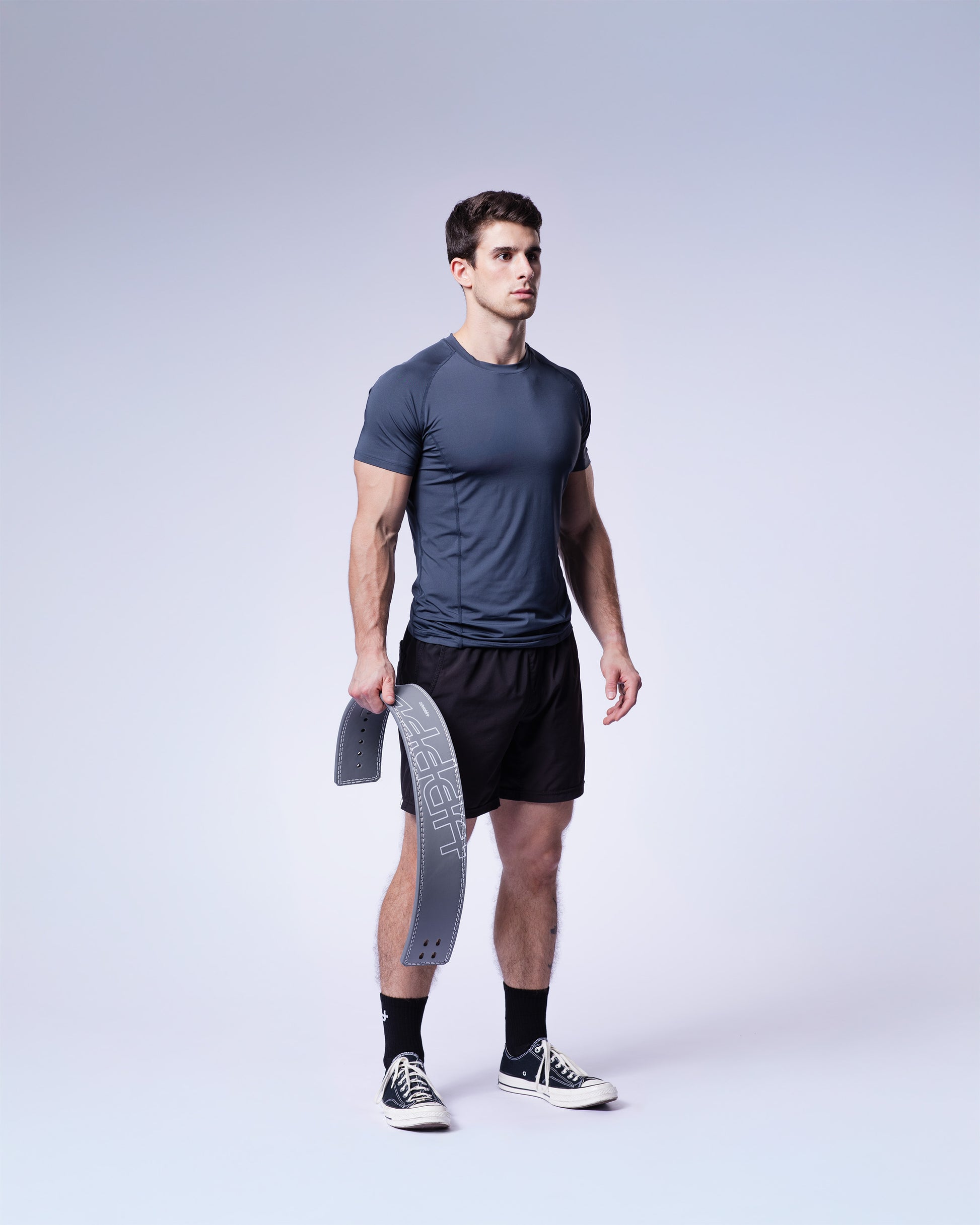 athlete holding a grey uppper lever belt on white background