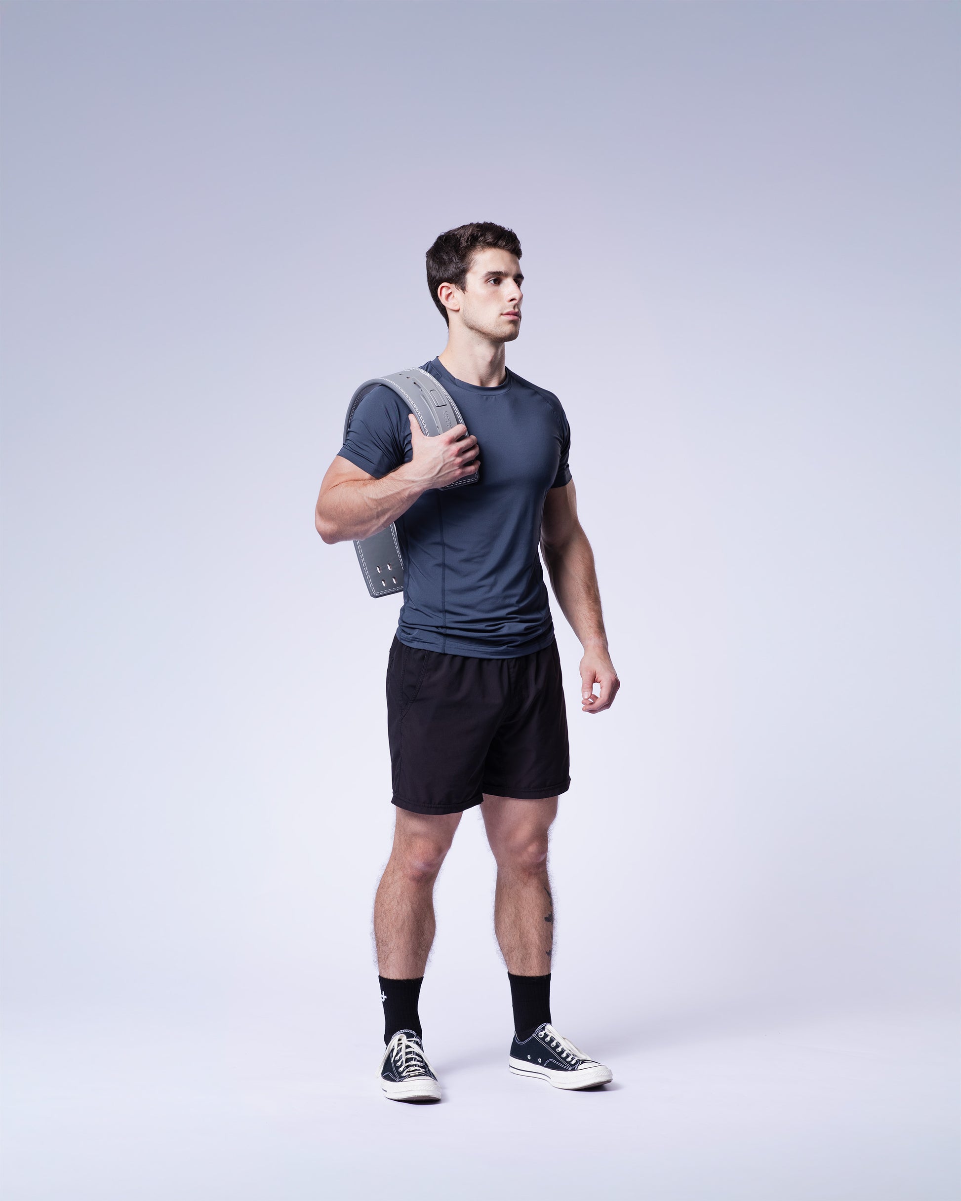 athlete holding grey uppper lever belt on white background 