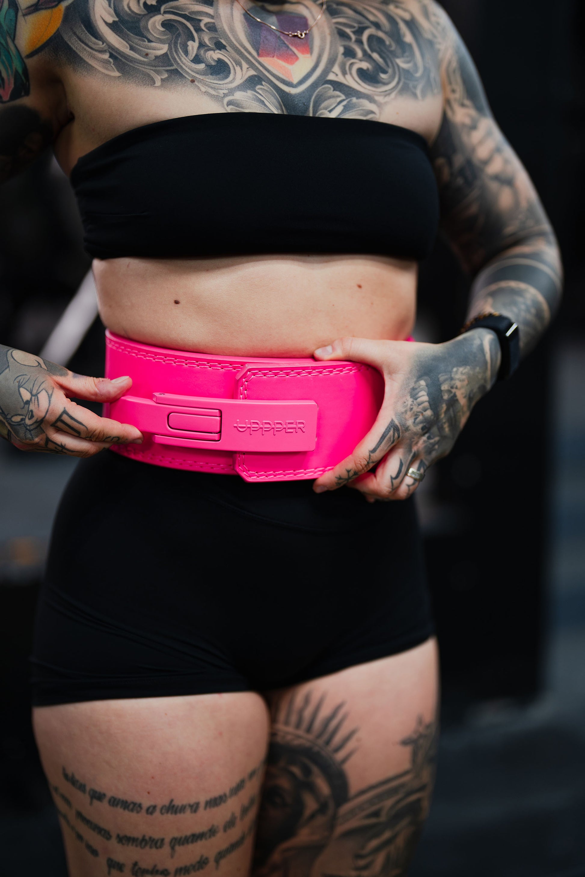 neon pink uppper lever belt close-up showing buckle clasp and logo embossing