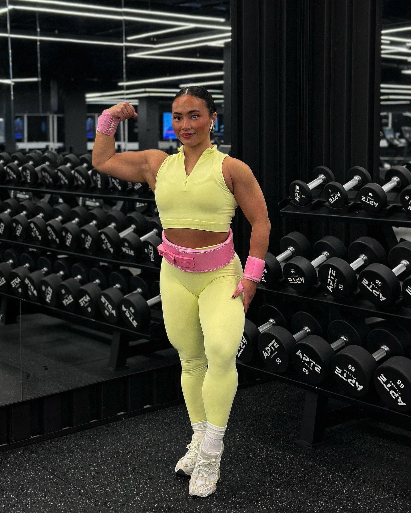 athlete posing in pink uppper lever belt and wrist wraps