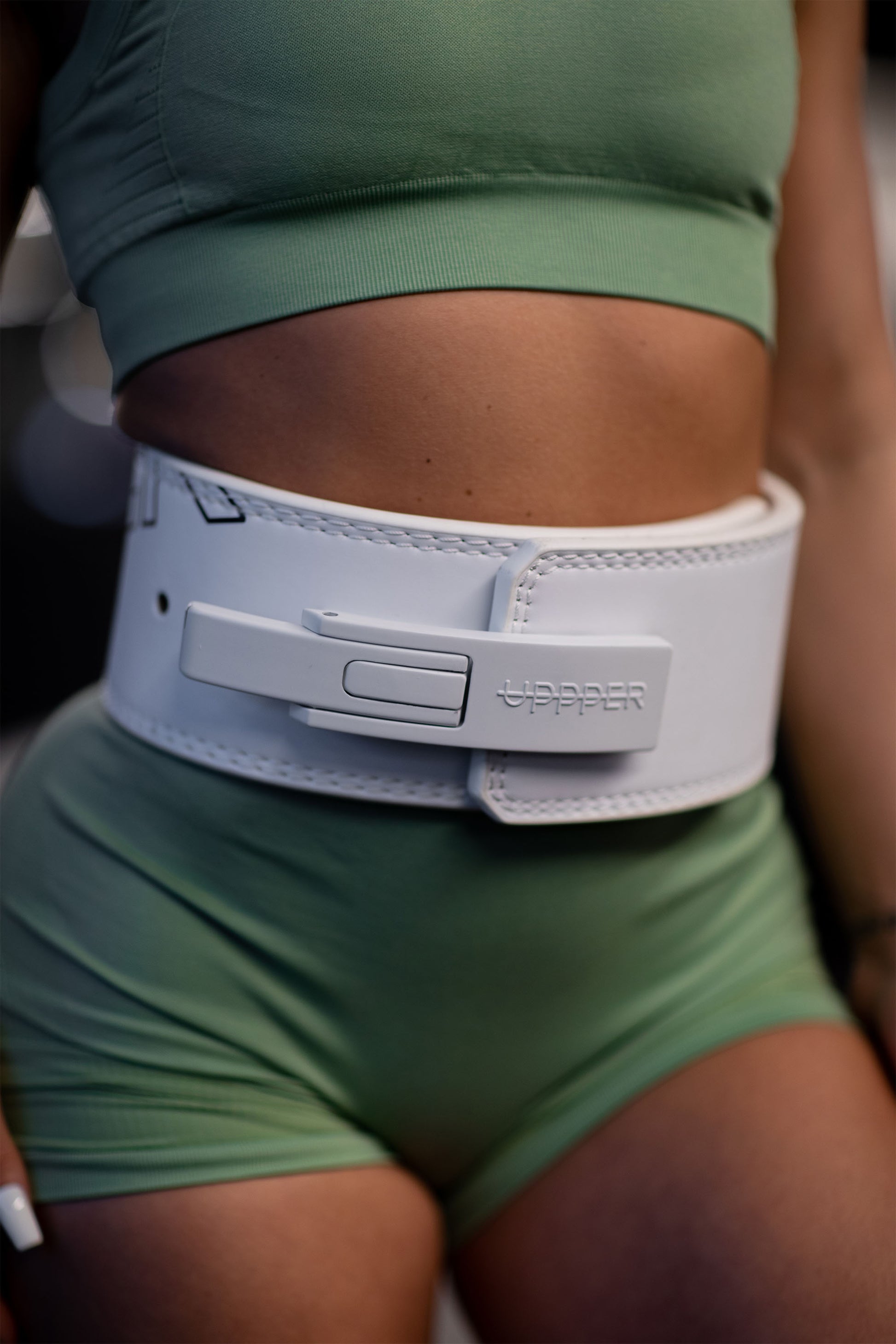 closeup of athlete wearing white uppper lever belt buckle details