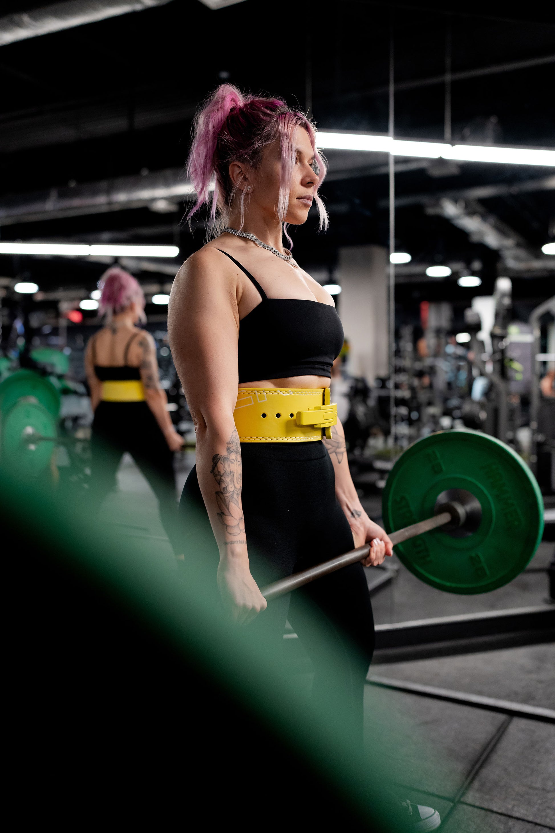 woman wearing yellow uppper lever belt while deadlifting