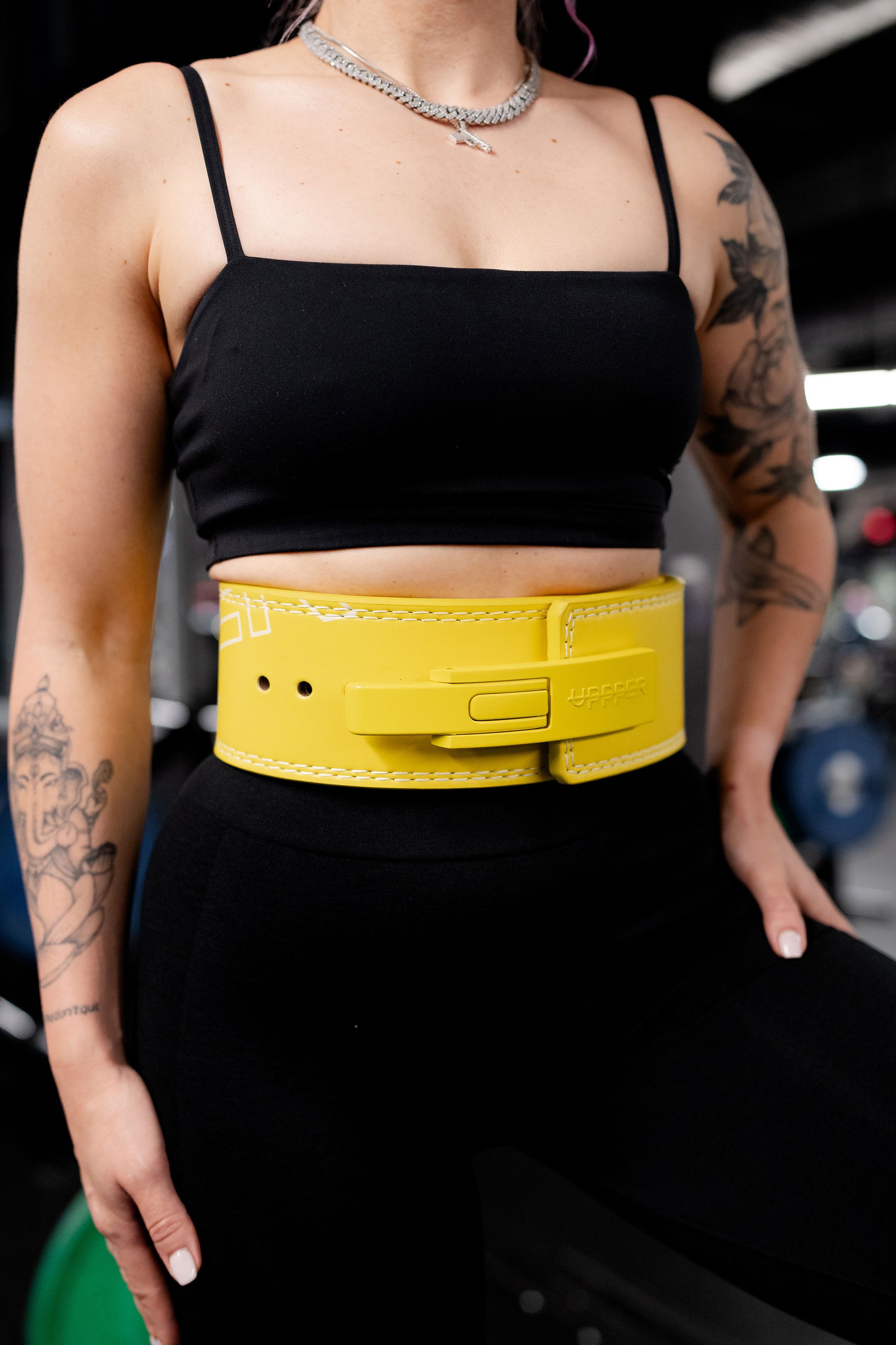 yellow uppper lever belt close-up showing buckle clasp and logo embossing