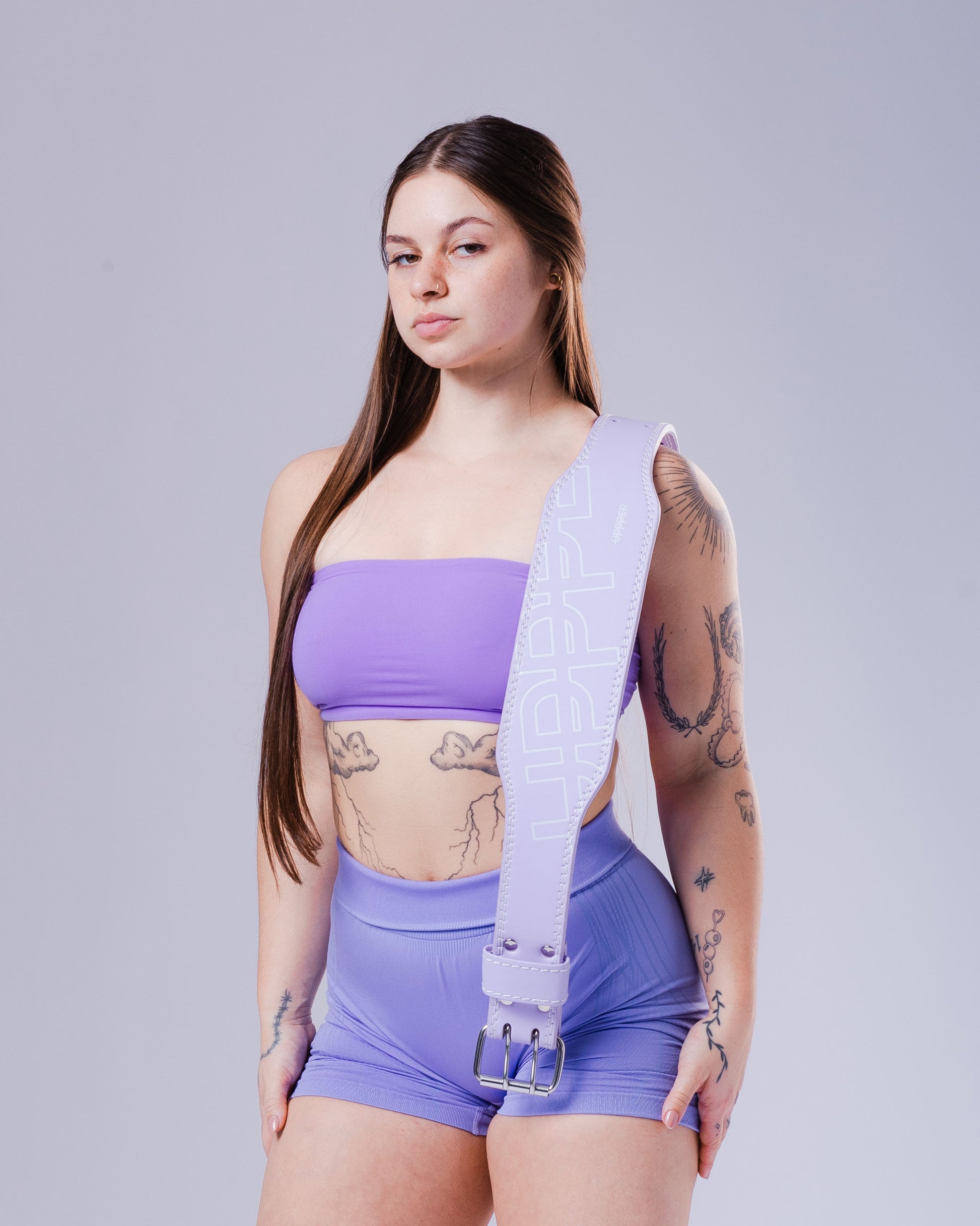 studio shot of model posing with lavender uppper lifting belt on shoulder showing front part 
