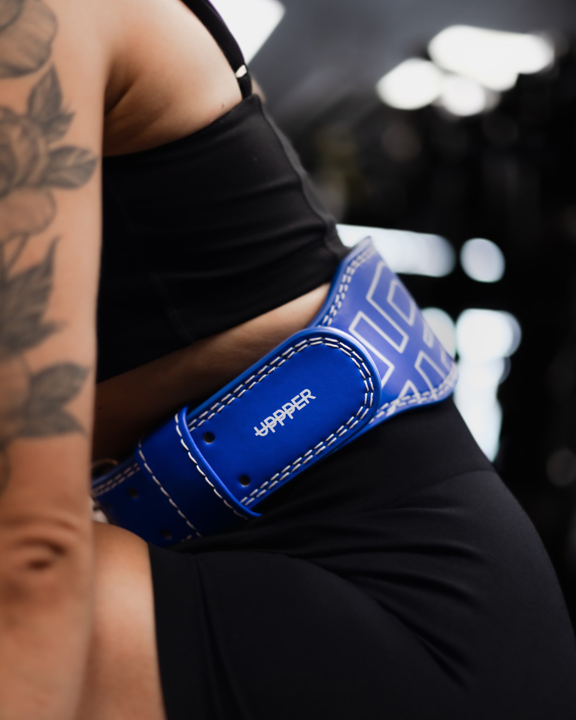 close up of blue lifting belt uppper showing stitching details and logo