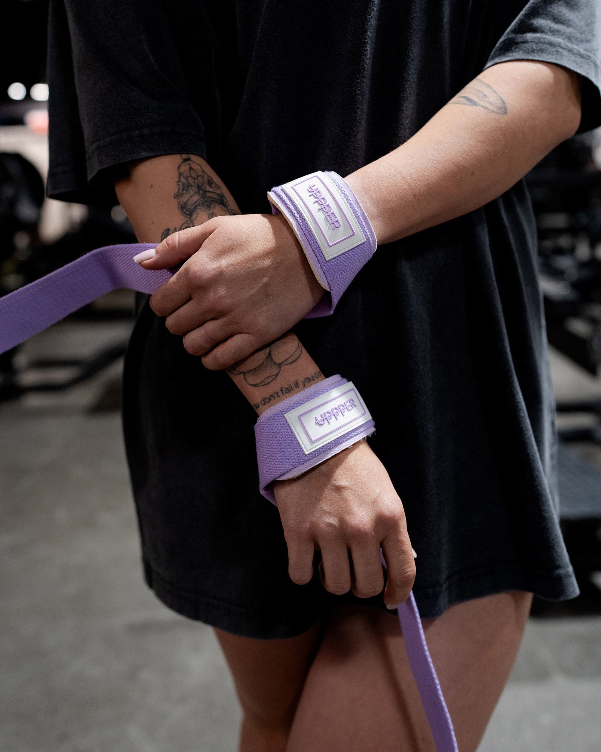 athlete wearing lavender uppper lifting straps looped showing strap length
