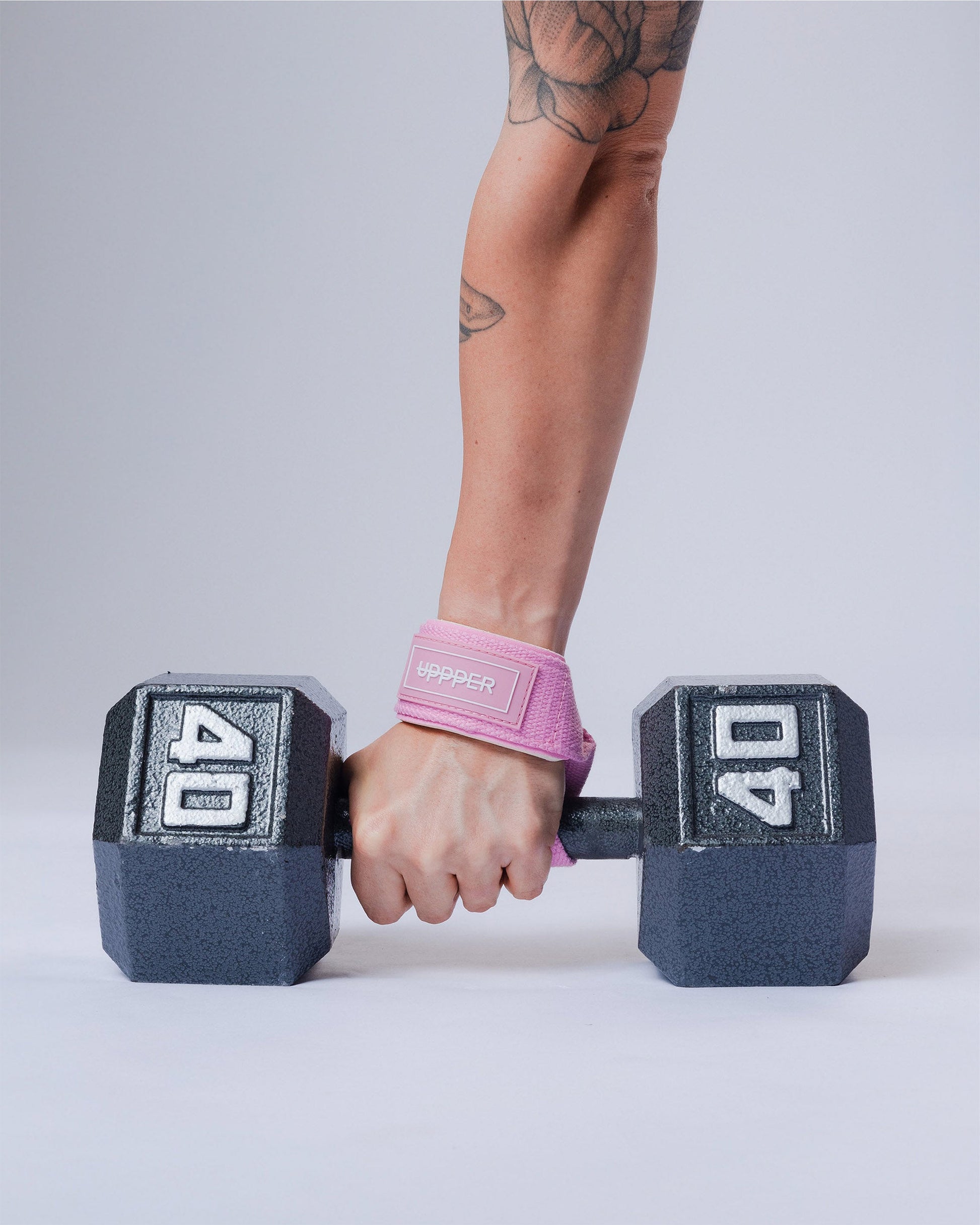 pink uppper lifting straps looped around dumbbell showing logo