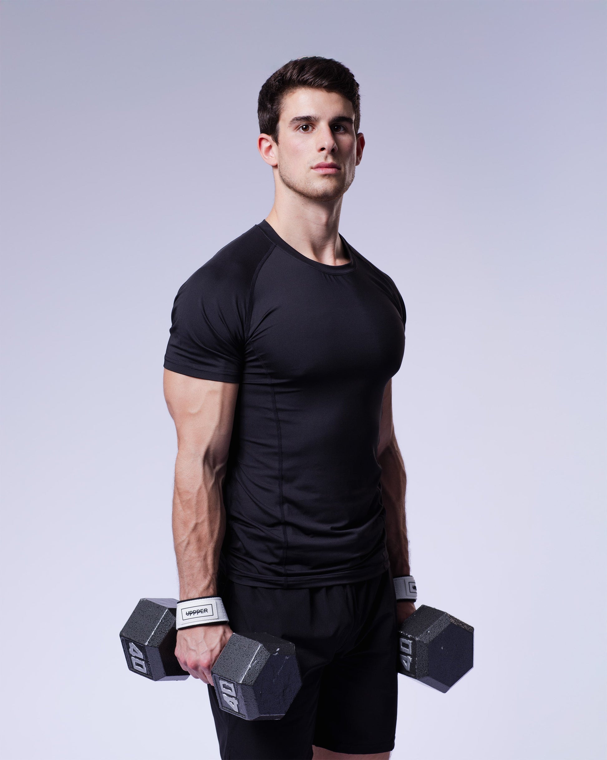 man wearing white uppper lifting strap holding dumpbell