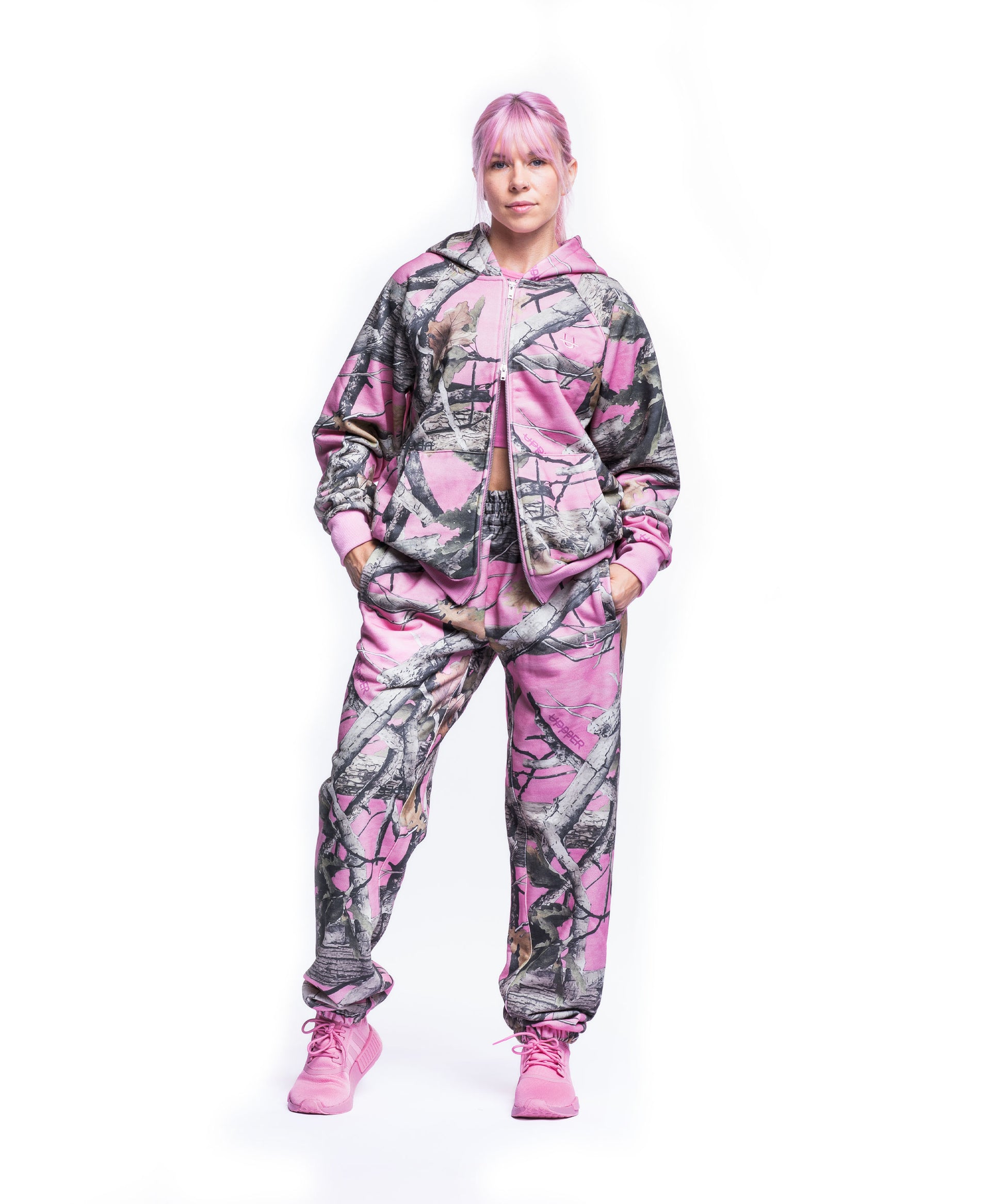 woman wearing pink camo uppper sweatsuit on white background
