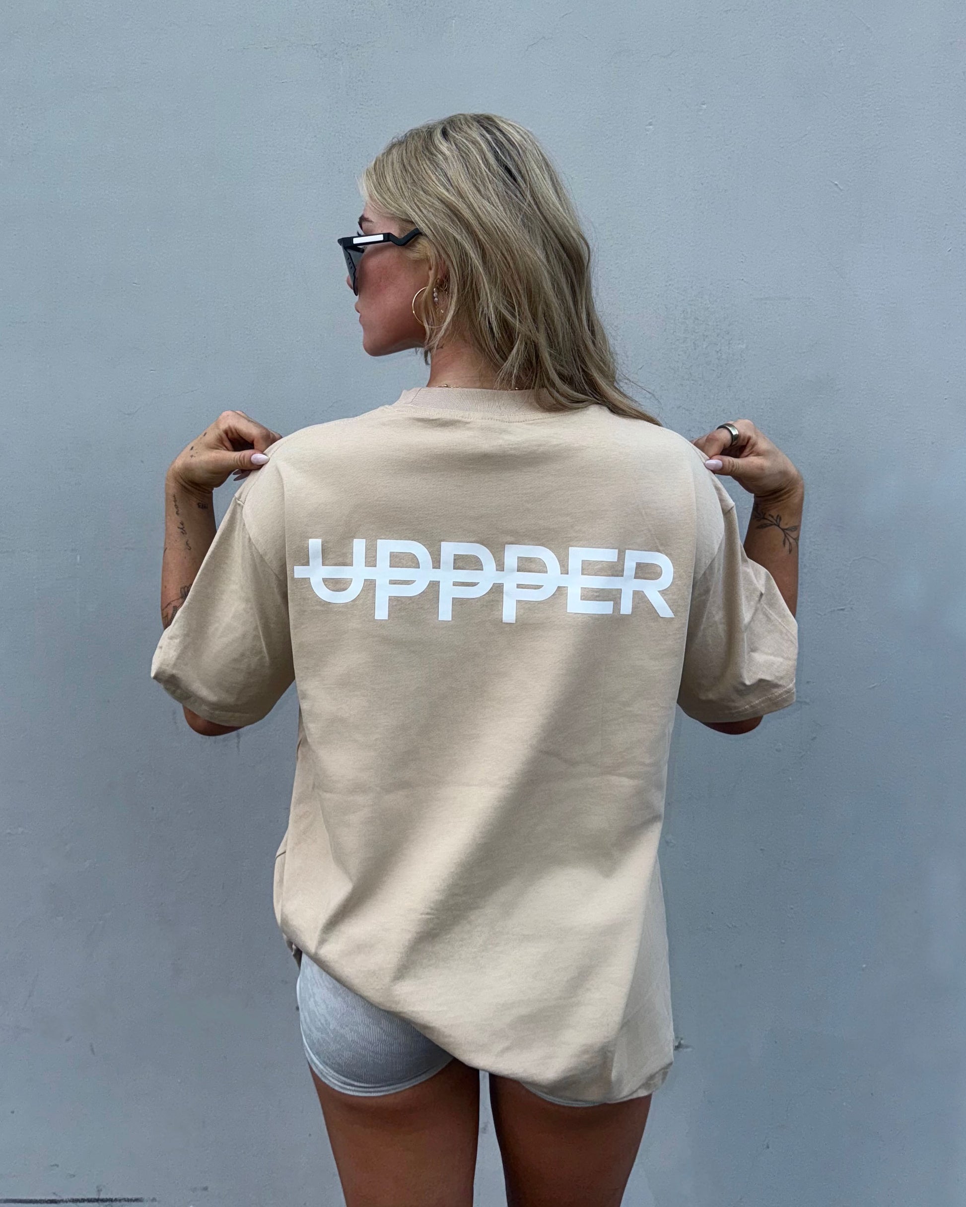 woman from behind showing white uppper text printed on back of white oversized t-shirt