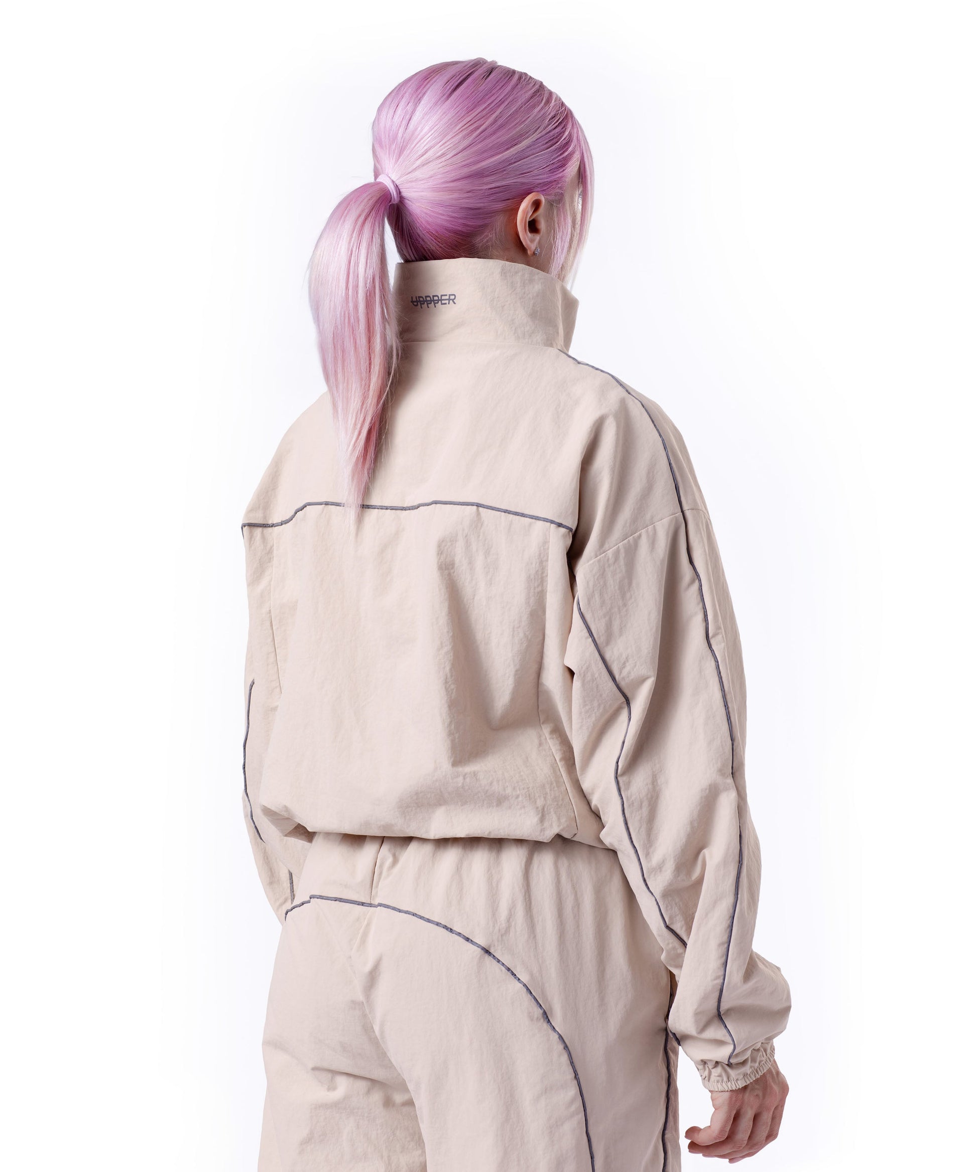 back of tan uppper track jacket showing reflective lines on white background