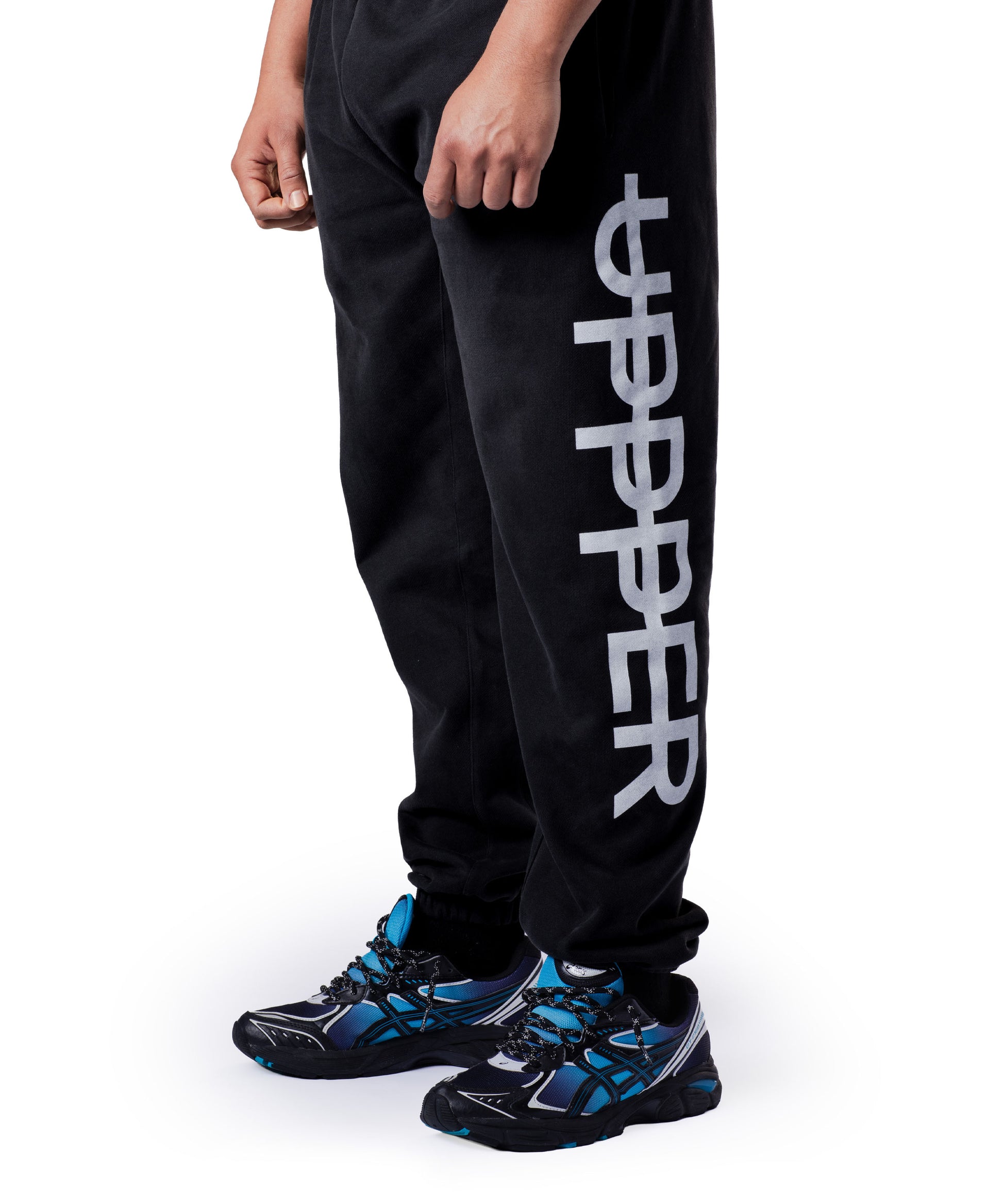 model wearing washed black uppper sweatpants on a white background