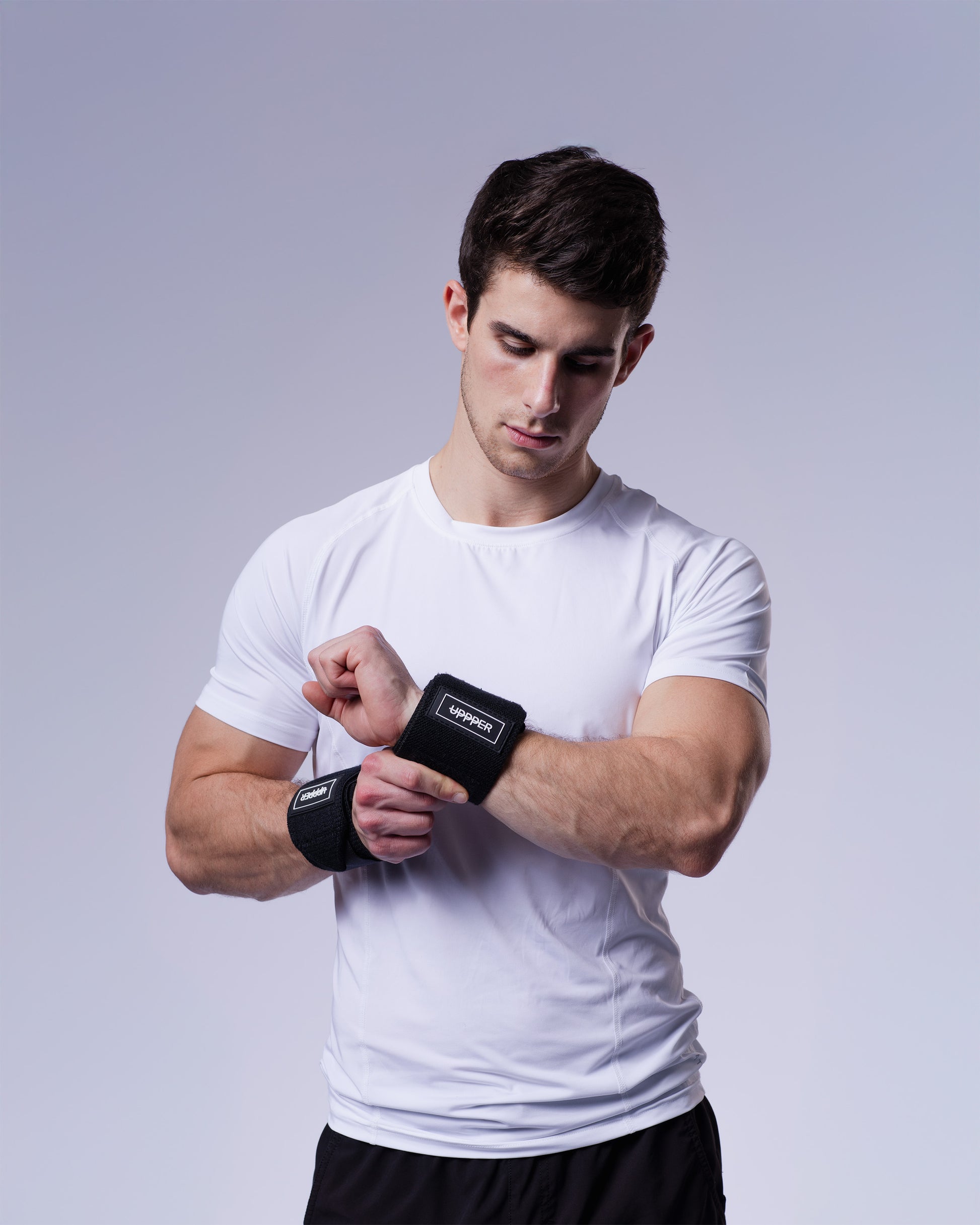 athlete wearing pair of black uppper wrist wraps showing fit and logo patch