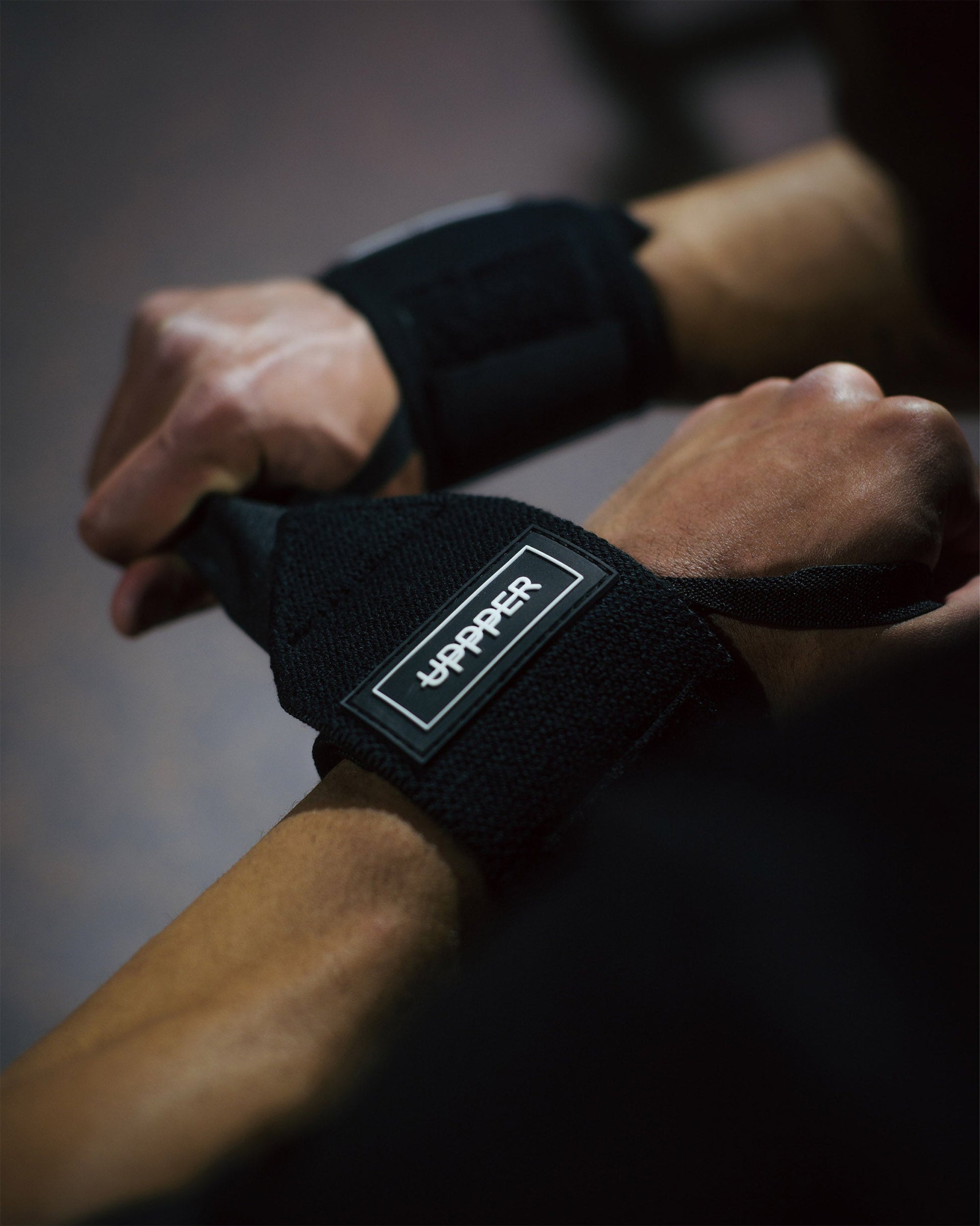 black uppper wrist wraps shown wrapped around wrist with velcro closure visible