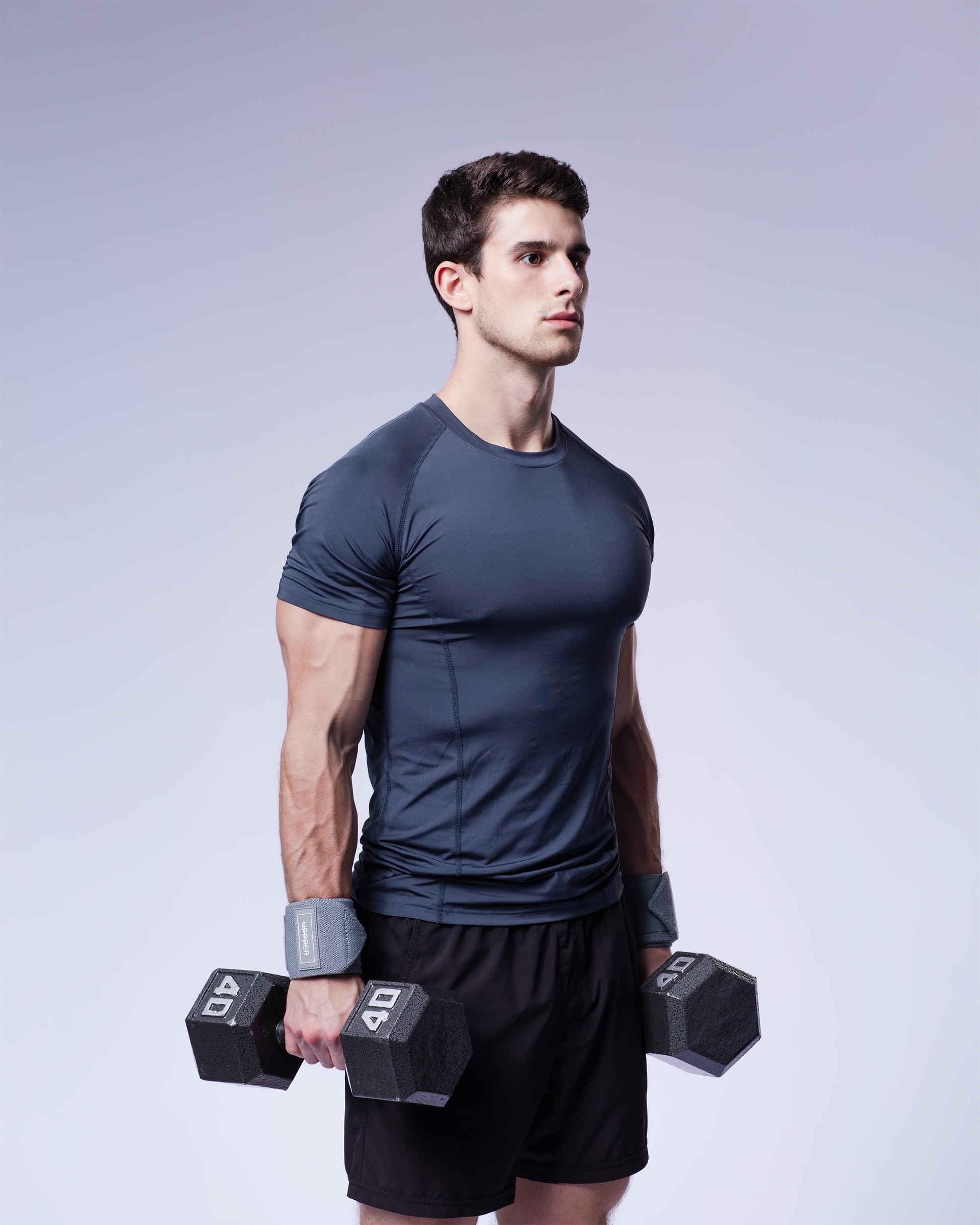 athlete in grey uppper wrist wrap holding dumbell