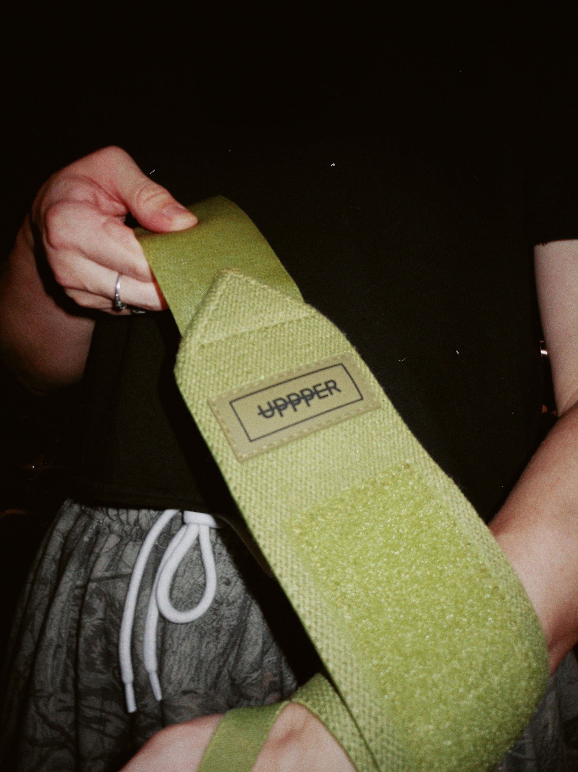 close-up of uppper wrist wraps in khaki color showing velcro detail and logo lifestyle shot