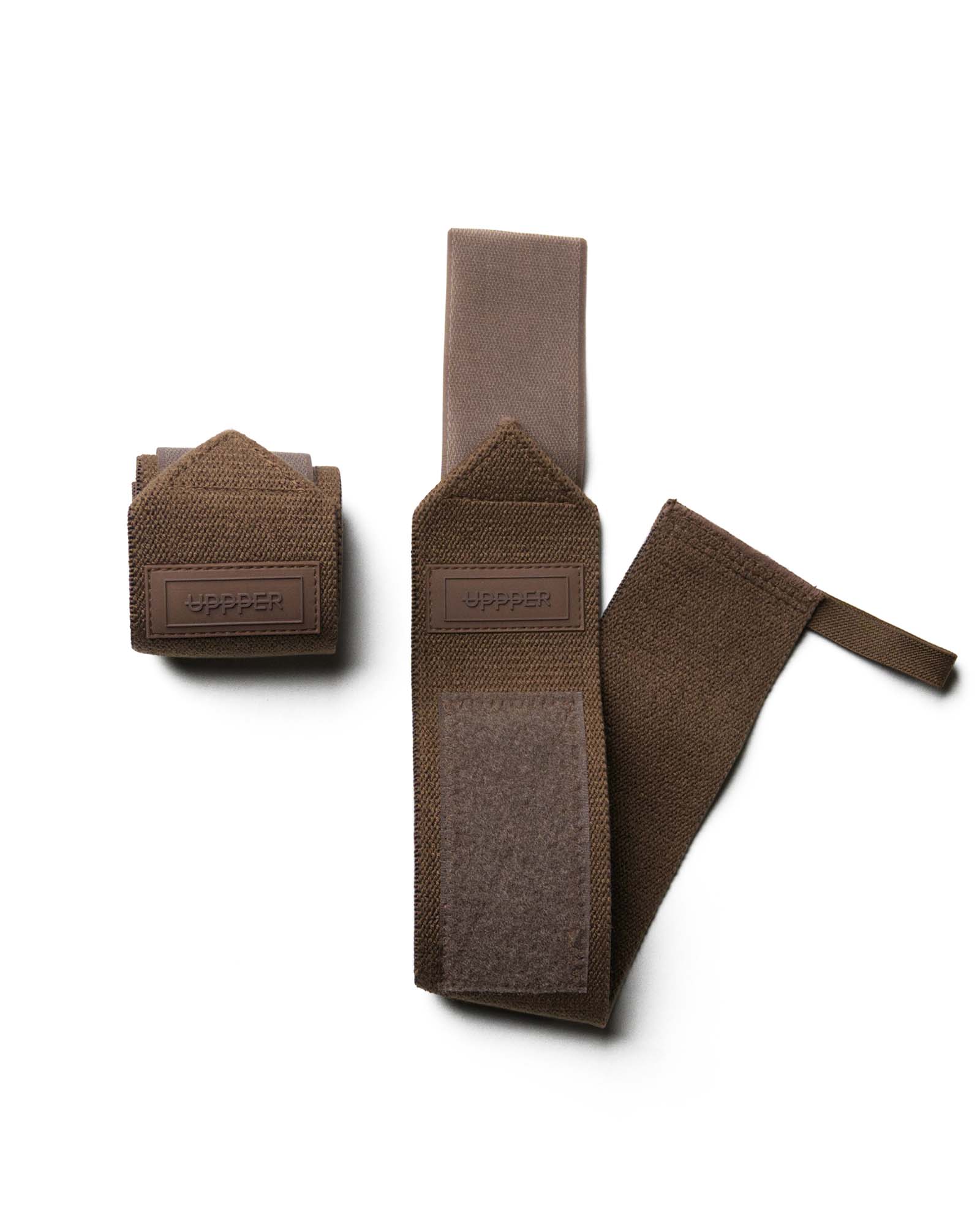 pair of umber uppper wrist wraps one rolled and one extended on white background