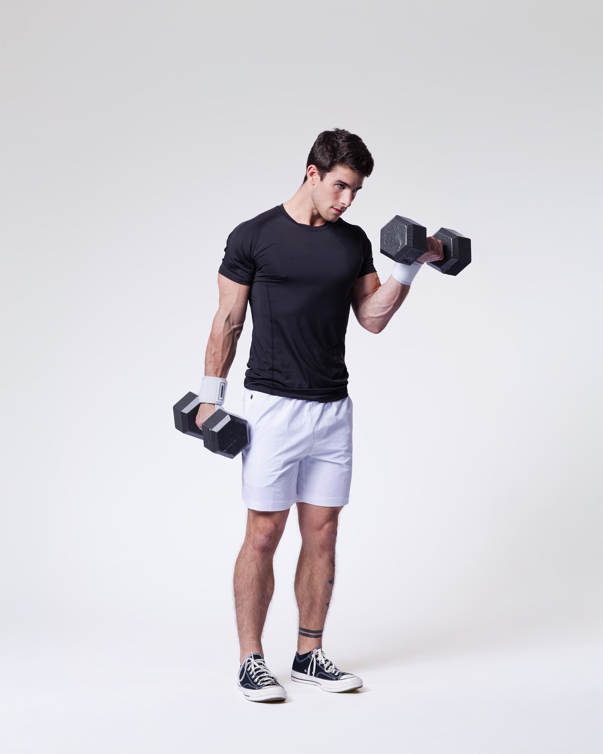 athlete performing exercise with dumbbells wearing white uppper wrist wraps