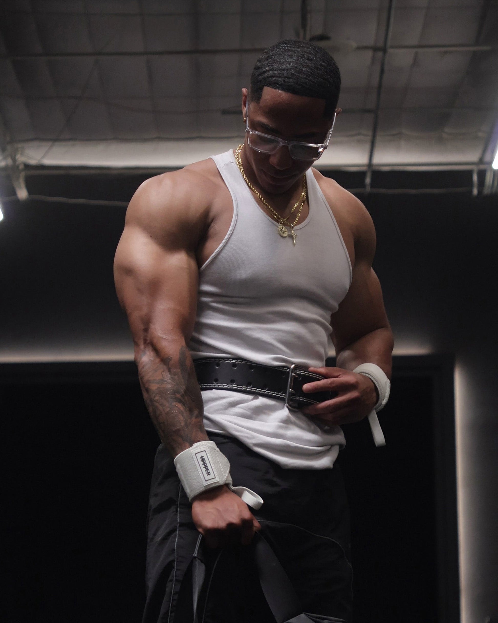 athlete posing in white uppper wrist wraps showing logo patch
