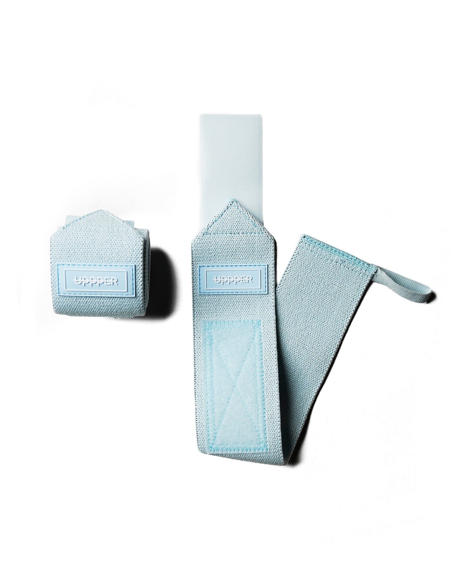 pair of baby blue uppper wrist wraps one rolled and one extended on white background
