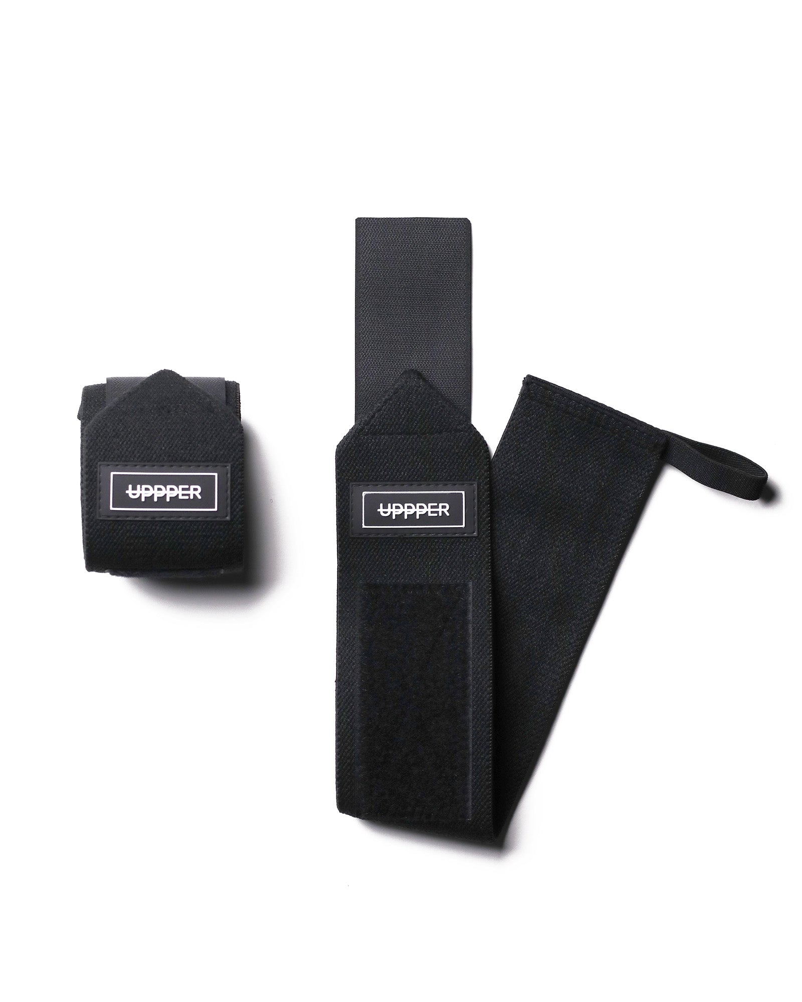 pair of black uppper wrist wraps one rolled and one extended on white background