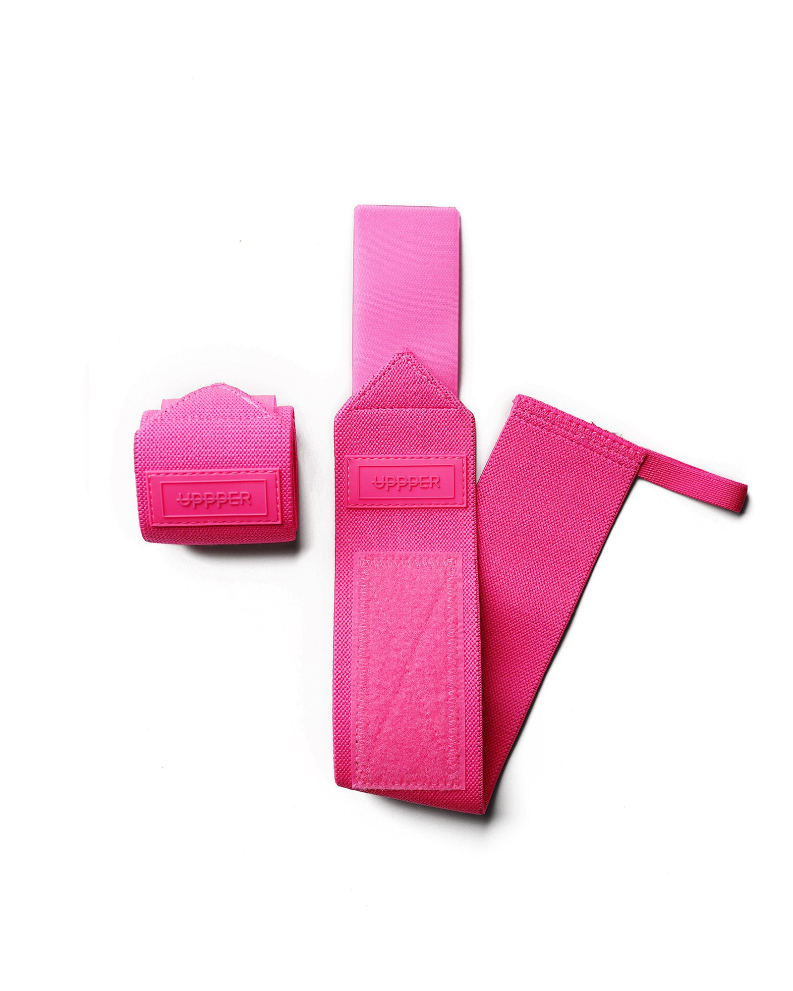 pair of neon pink uppper wrist wraps one rolled and one extended on white background