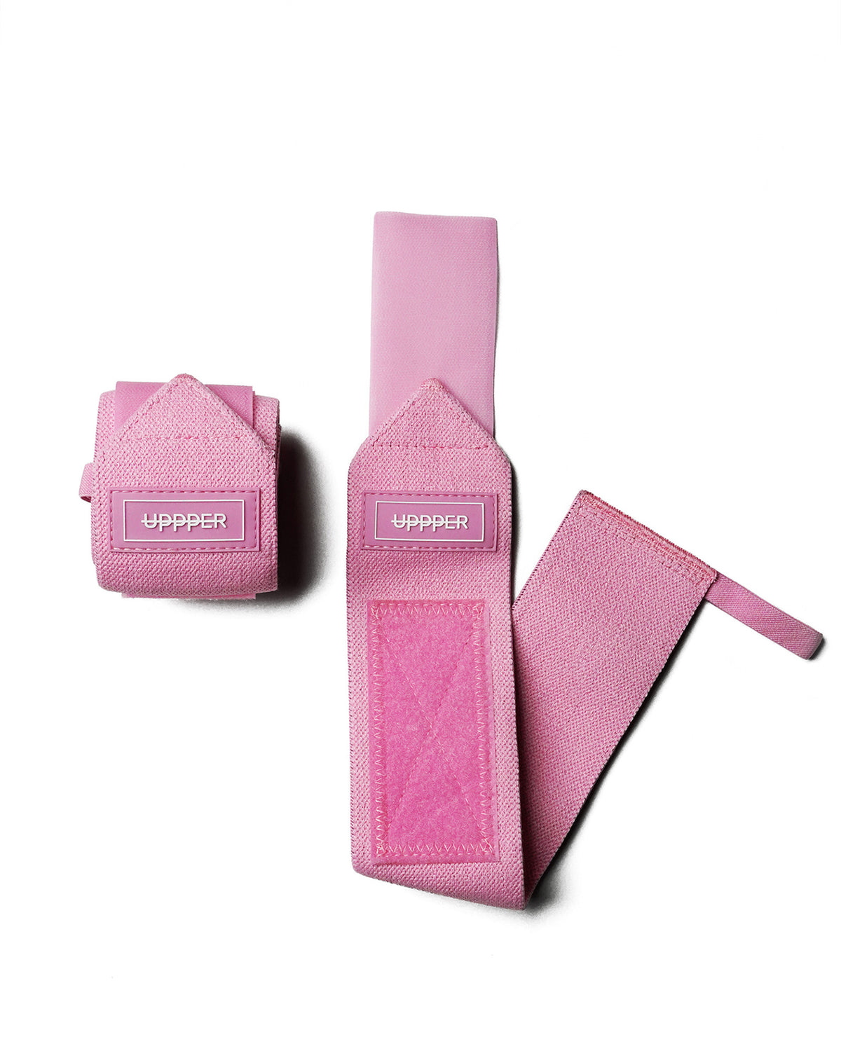 pair of pink uppper wrist wraps one rolled and one extended on white background