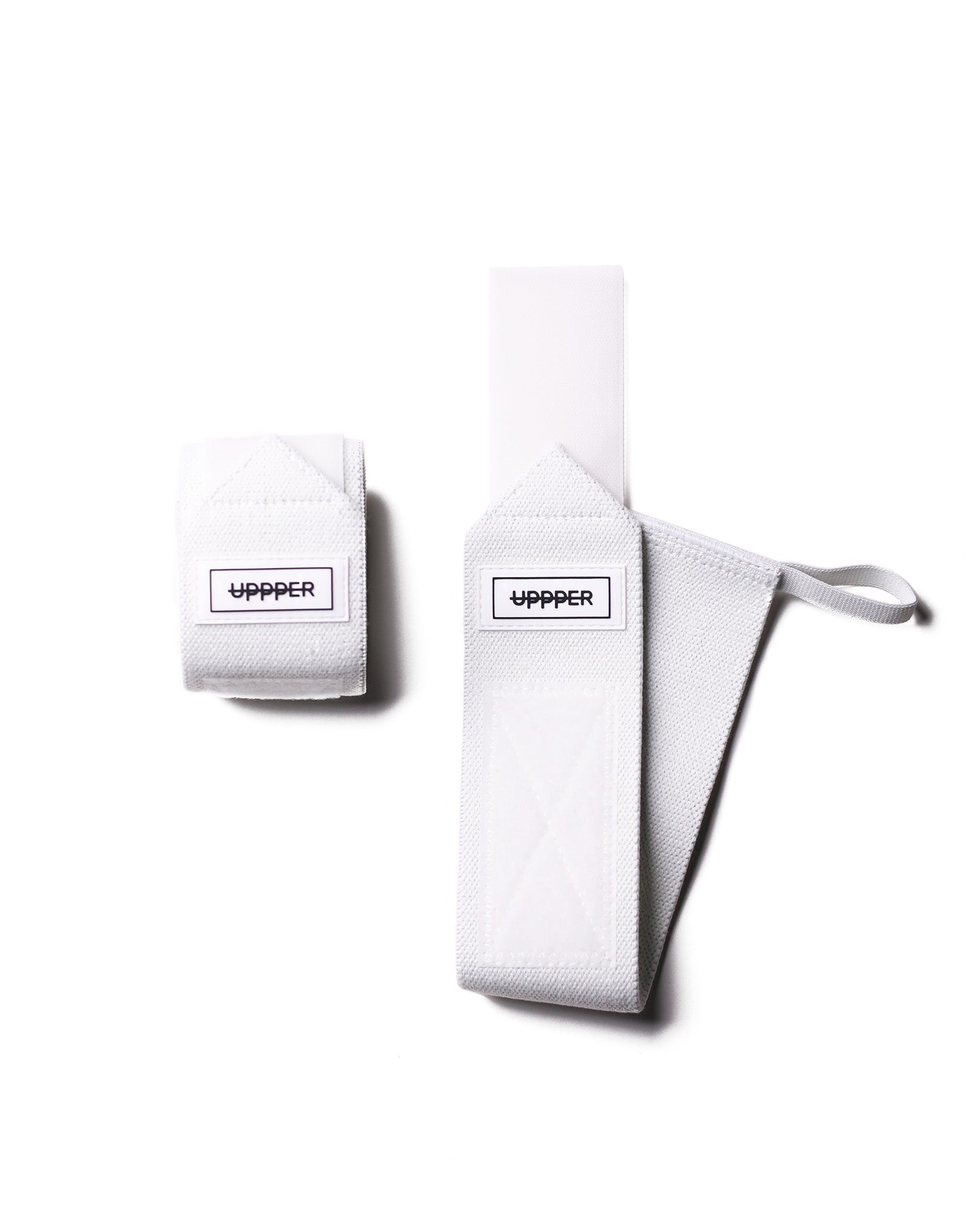 pair of white uppper wrist wraps one rolled and one extended on white background